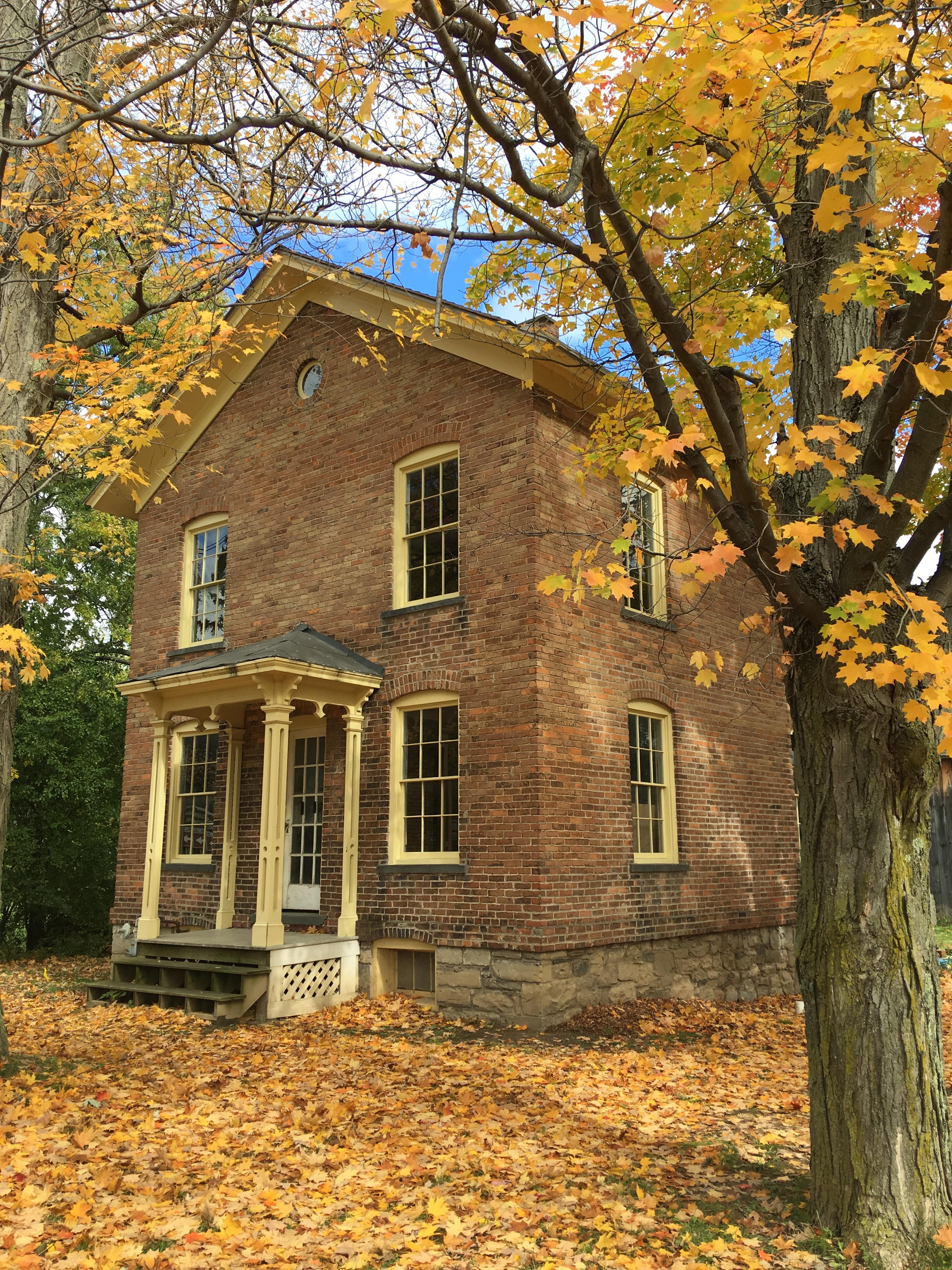 Brick building surrounded by autumn trees