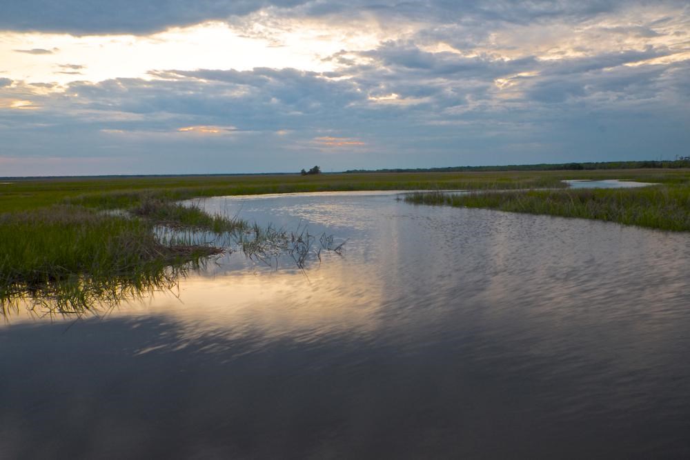 Winding river surrounded by grasslands on a cloudy day. 
