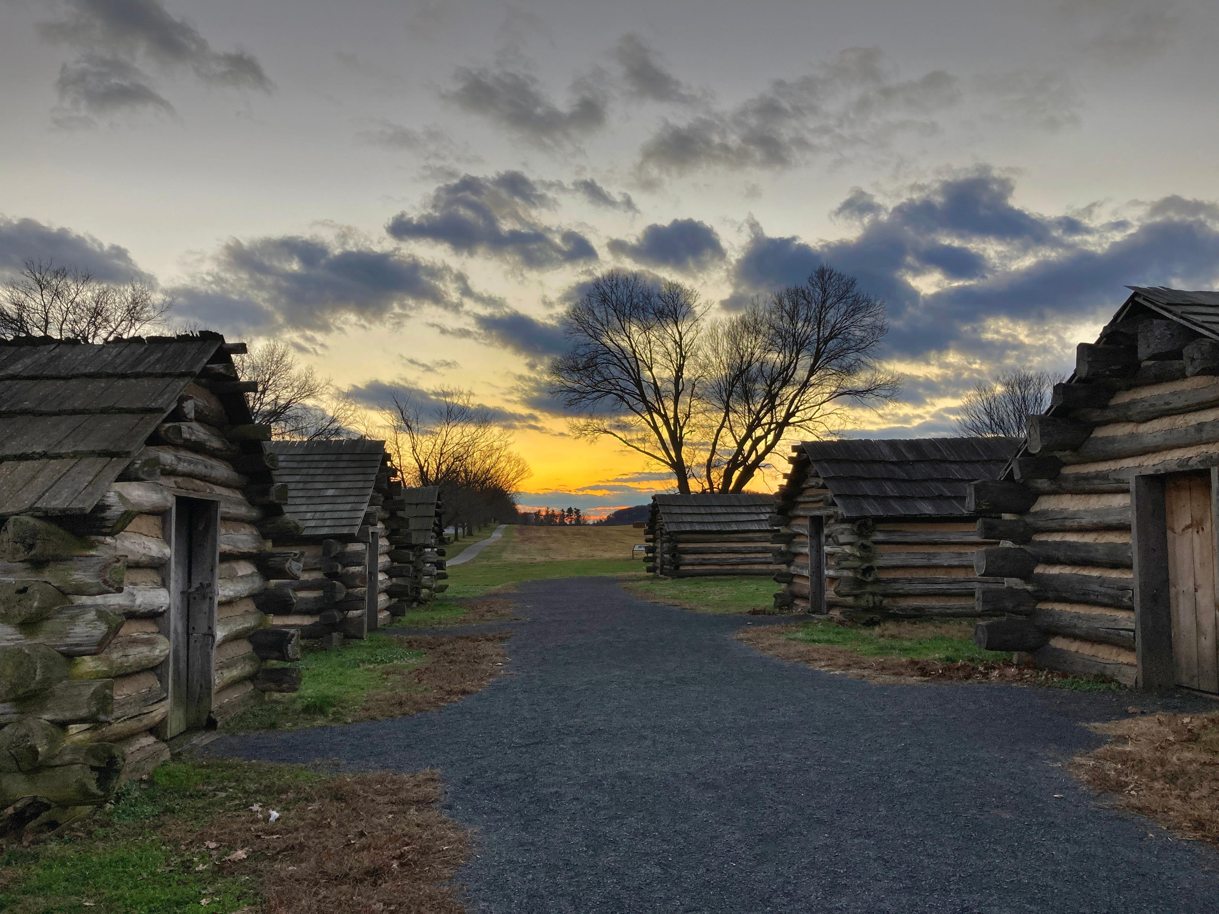 outdoors, log huts, gravel path, sunset, clouds