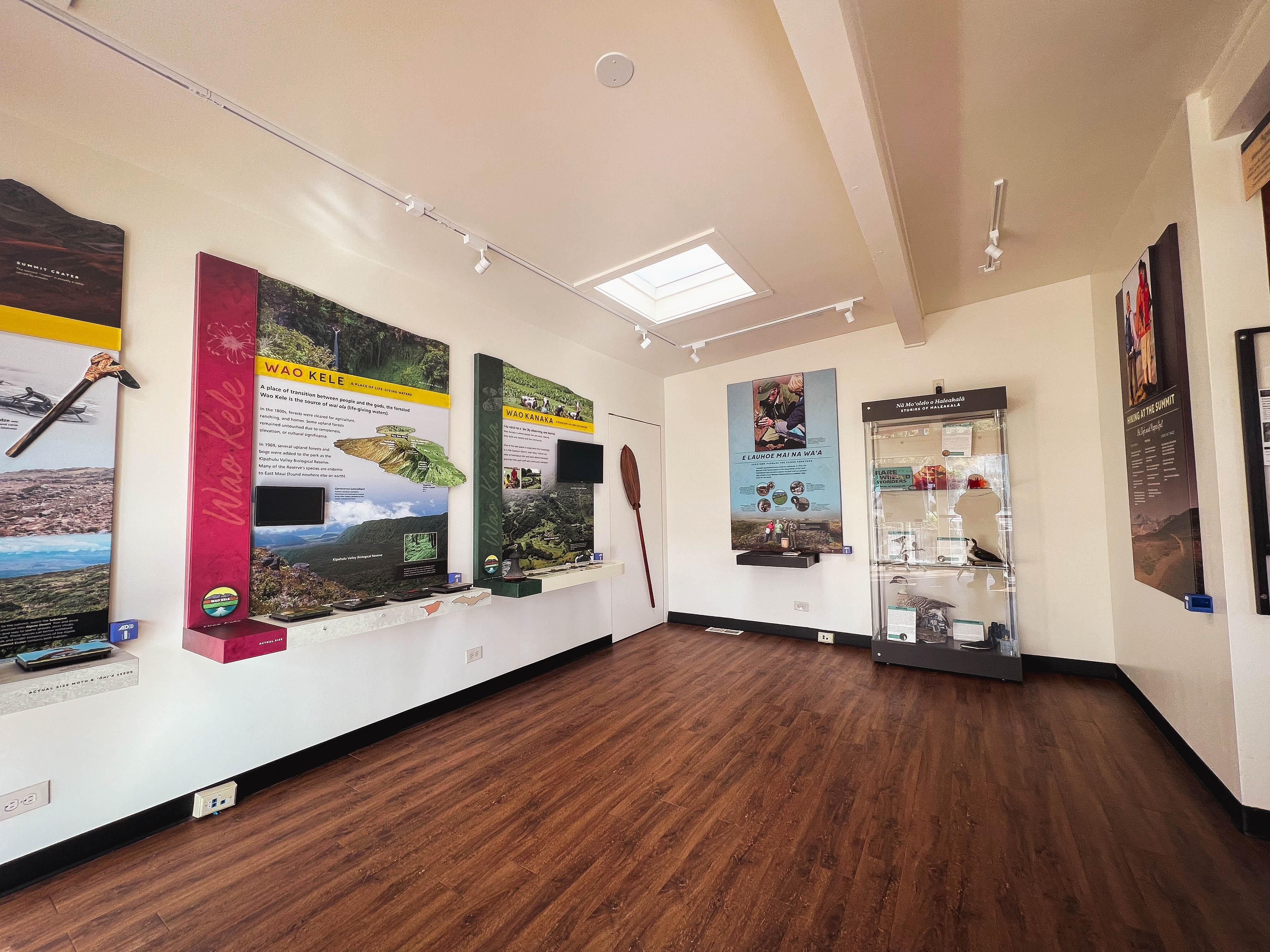 Colorful displays with park information line the white walls of a room