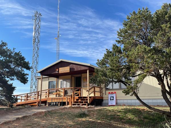 Hans Flat Ranger Station building, flag pole and shade structure on a sunny morning.