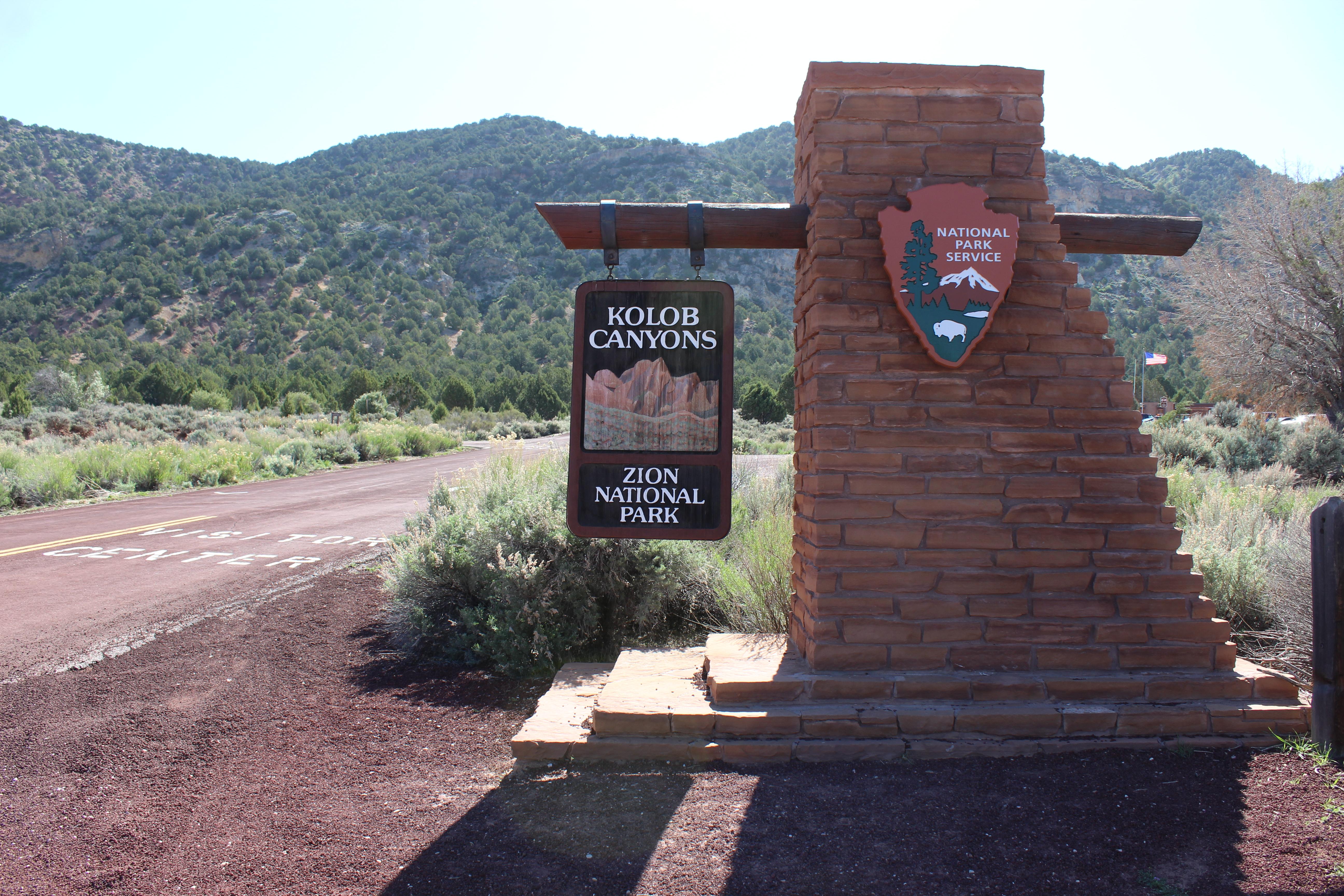 A stone monument with a wooden sign the says Kolob Canyons - Zion National Park