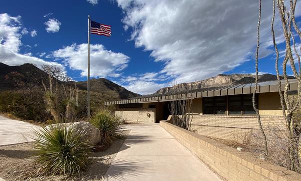 Sidewalks lead to a stone building with a breezeway.