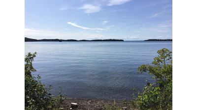 Shoreline of Todd Harbor, Lake Superior with blue sky and barrier islands.