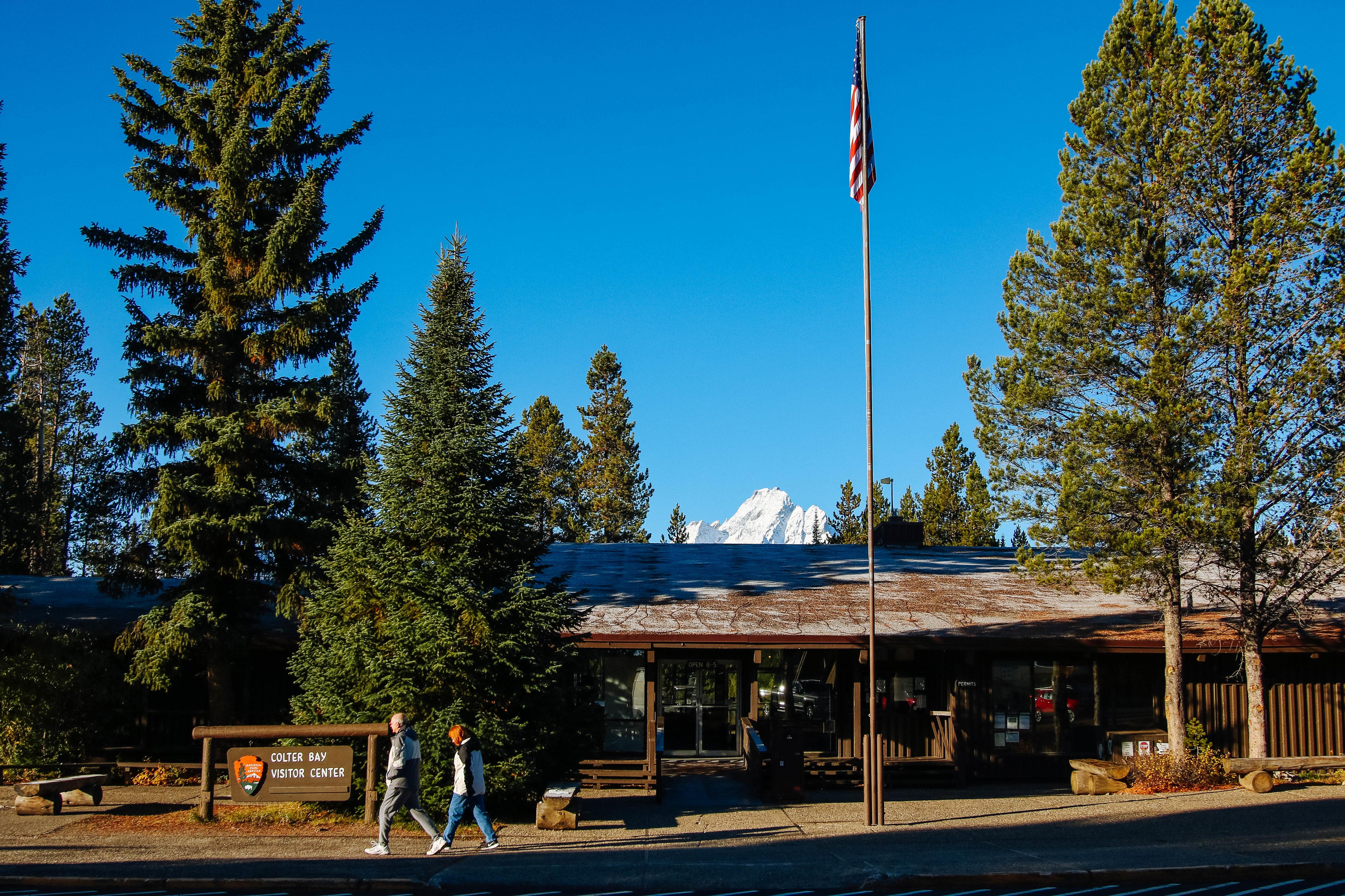 Long low slung board and batten building with American flag on pole out front.
