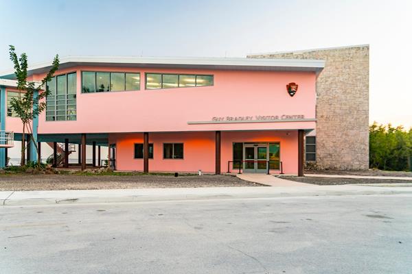 A large pink building with "Guy Bradley Visitor Center" above the double-door entrance.