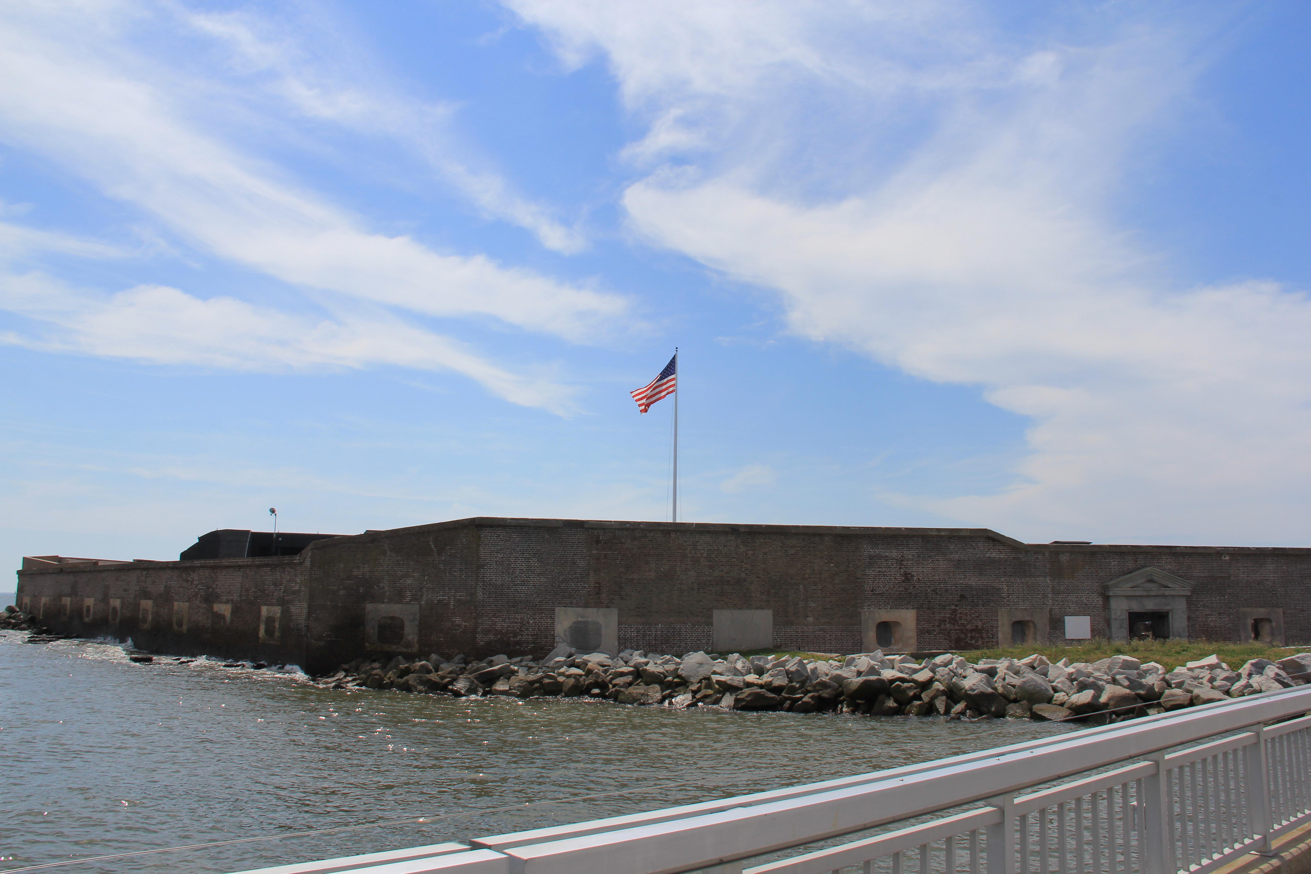 Fort Sumter with a US flag flying above the fort with dock in the foreground