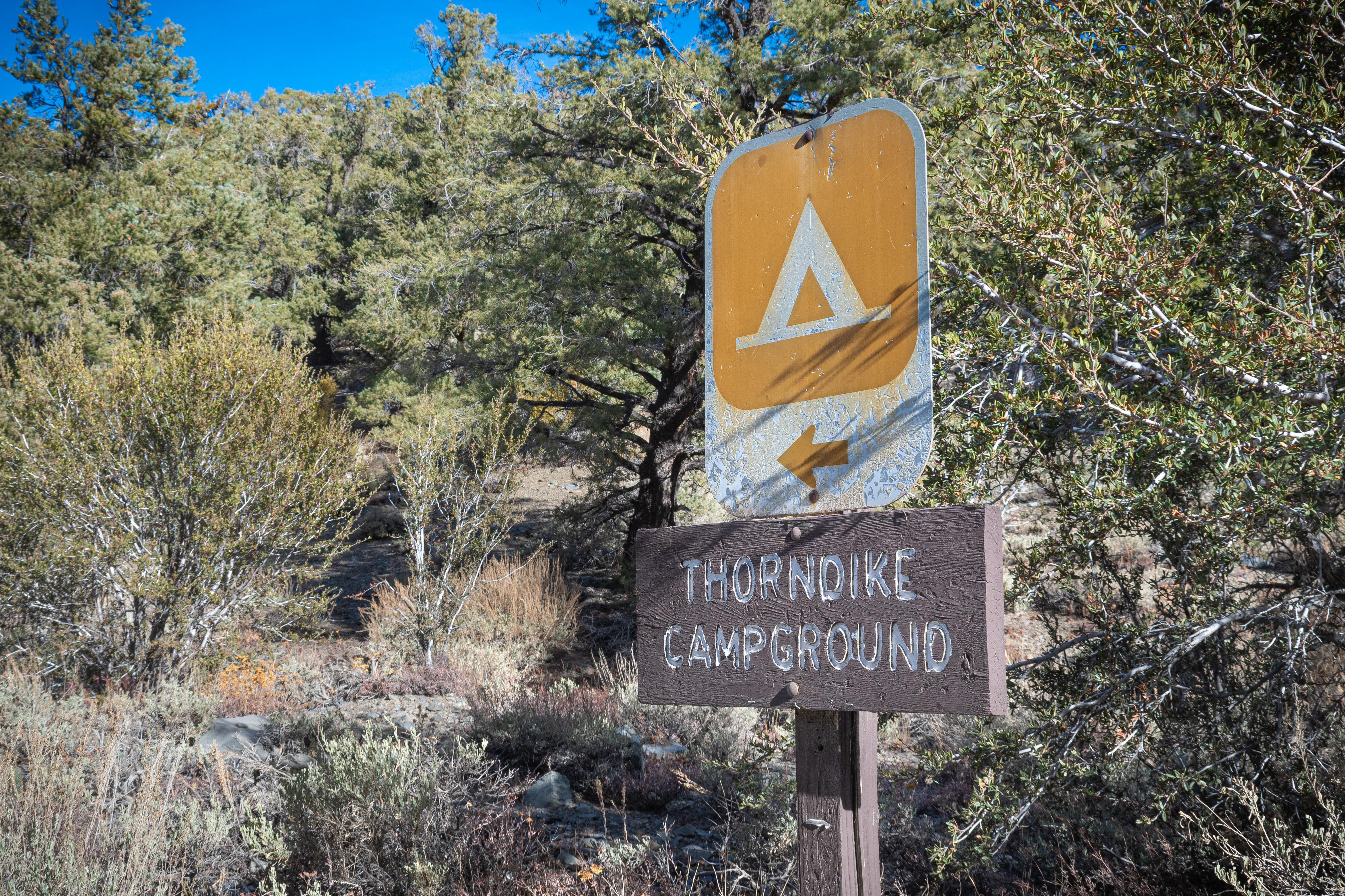 2' metal tent sign on top of small wood horizontal sign on a post reads, Thorndike Campground.