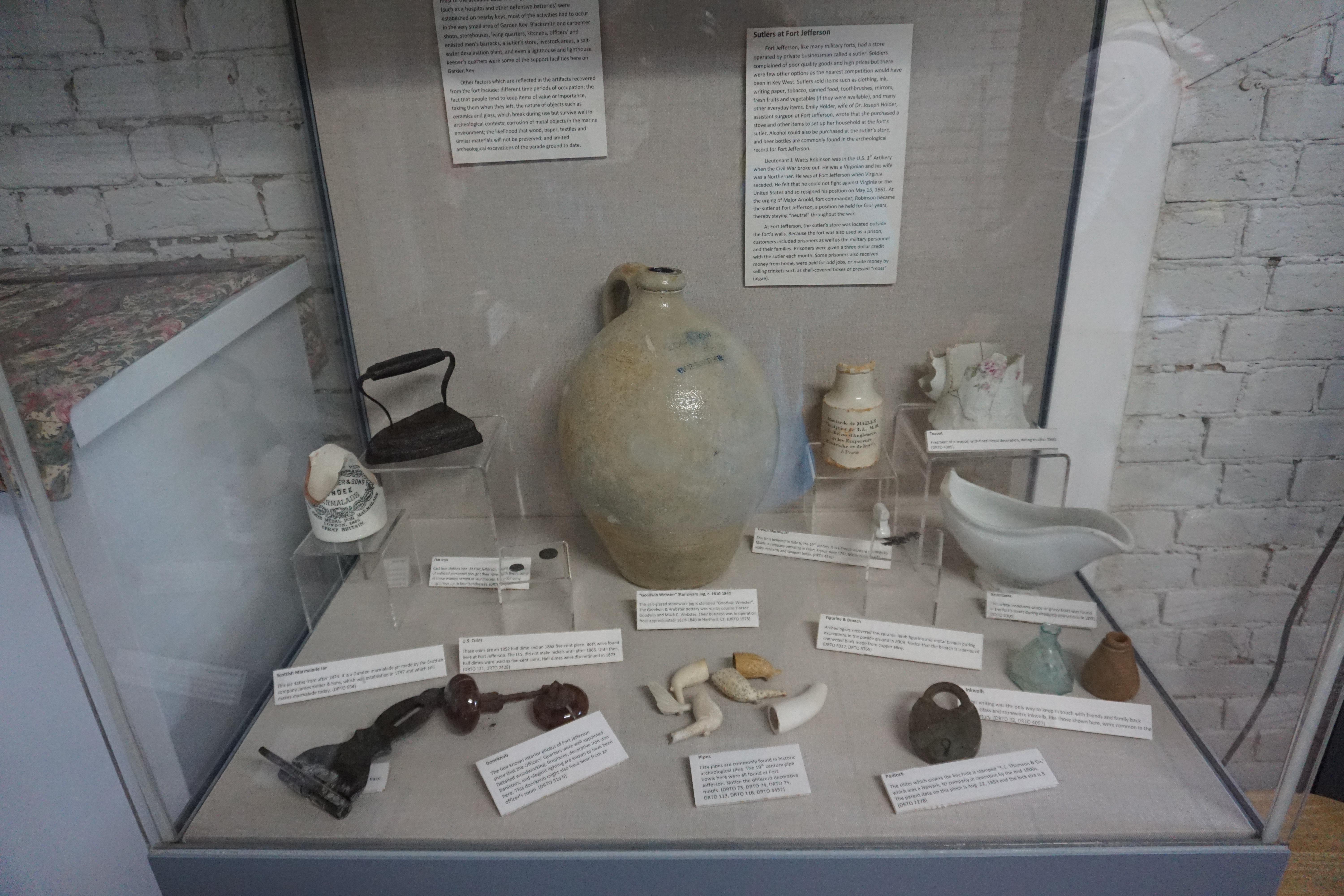 A glass case displays a dozen ceramic vases, tools and artifacts which have been preserved