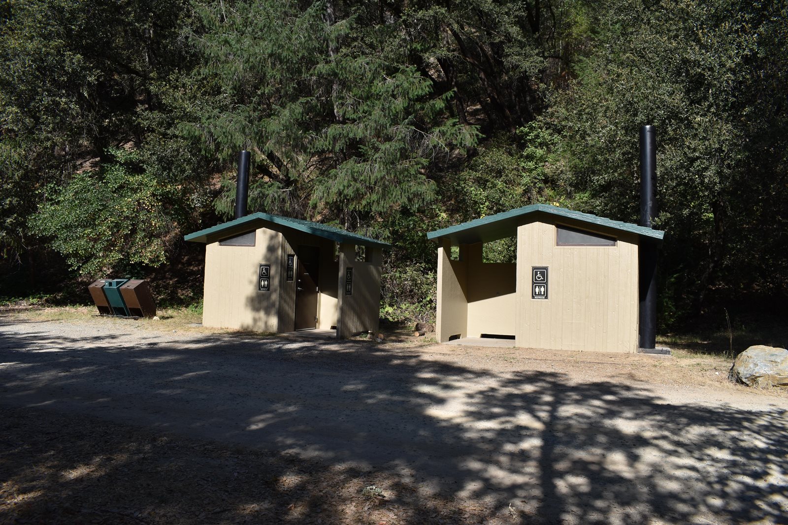 Vault restrooms at Peltier Bridge Campground, two serving all nine sites