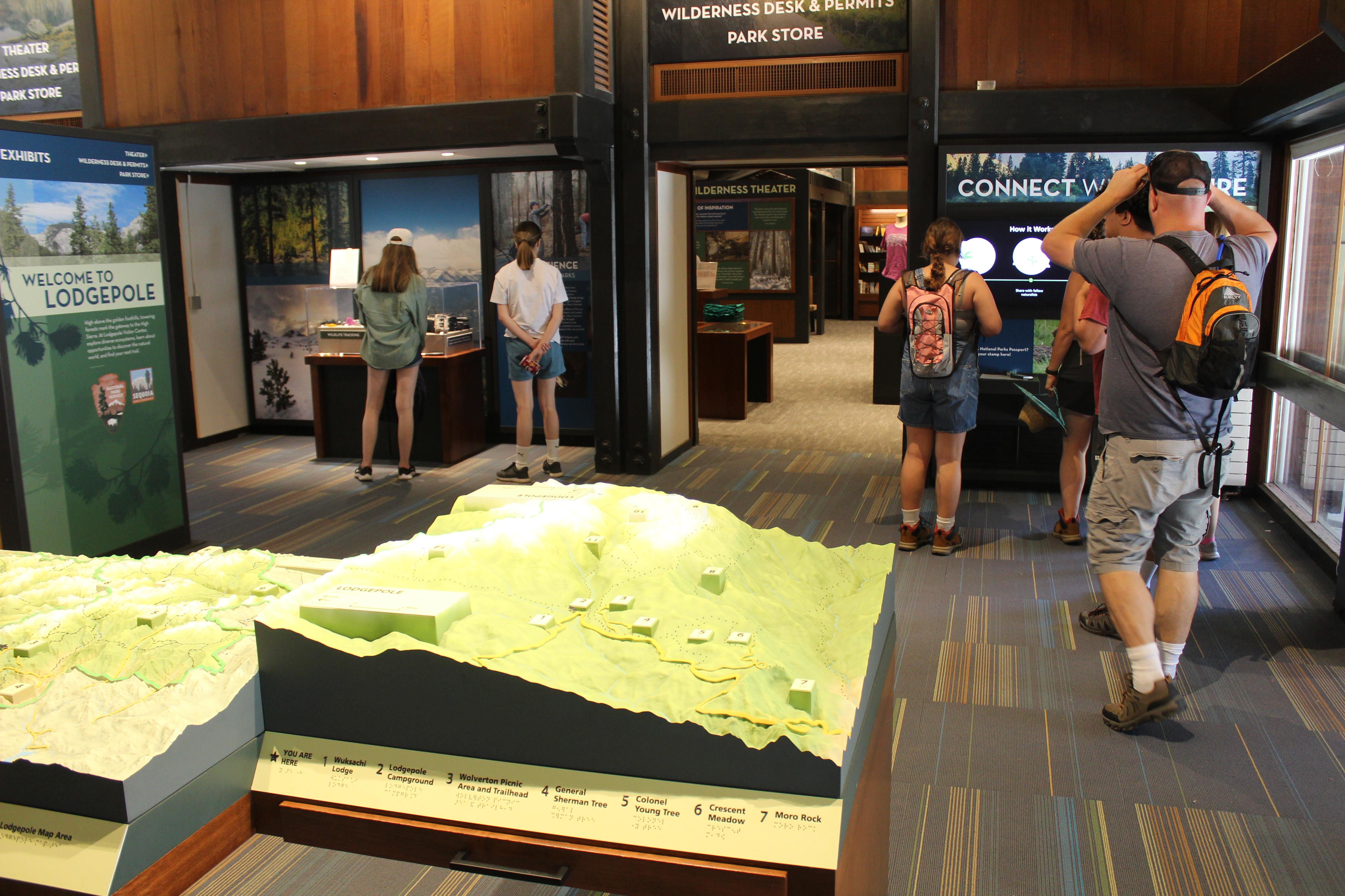 visitors look at visitor center displays and maps