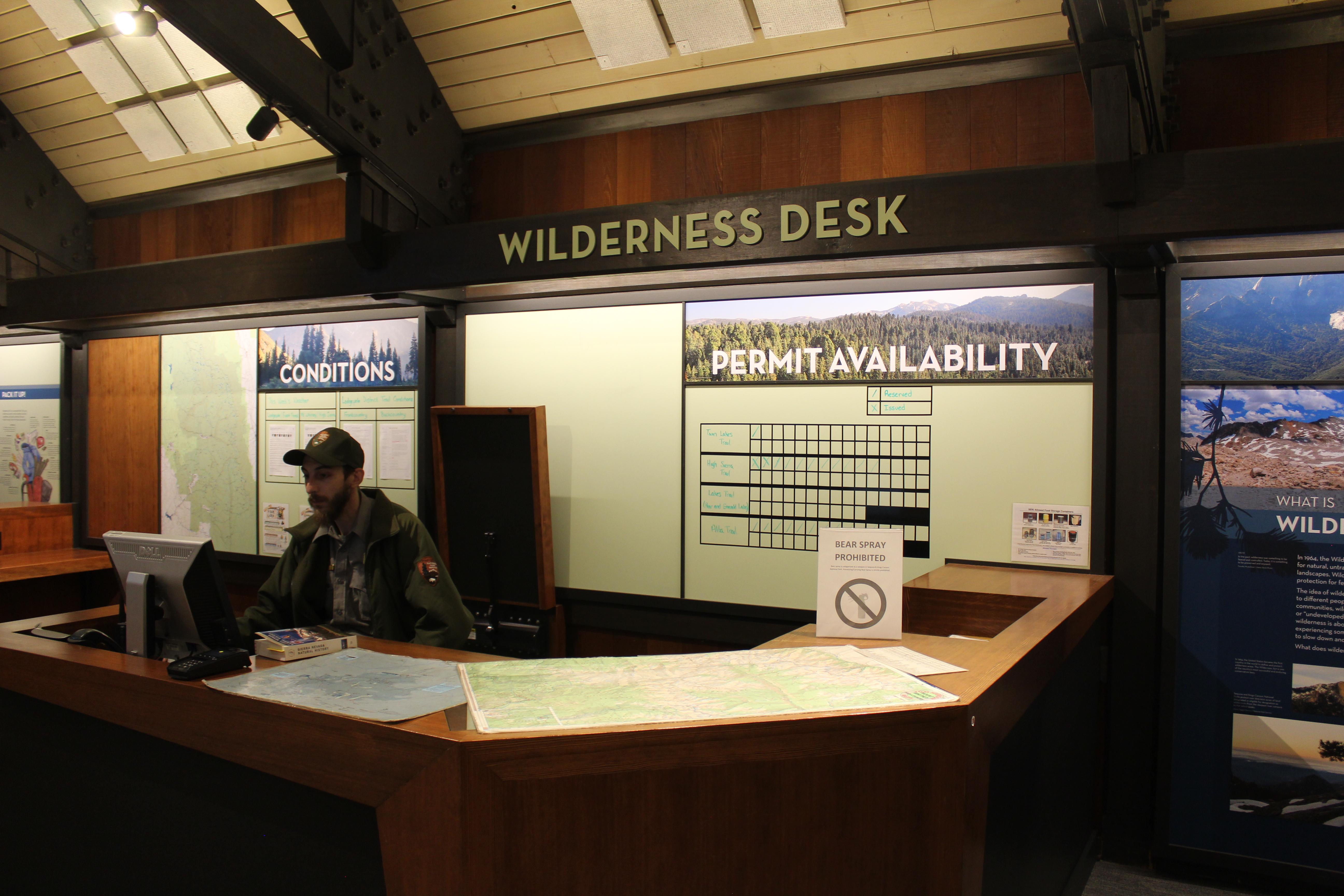 a wilderness ranger sits behind a computer