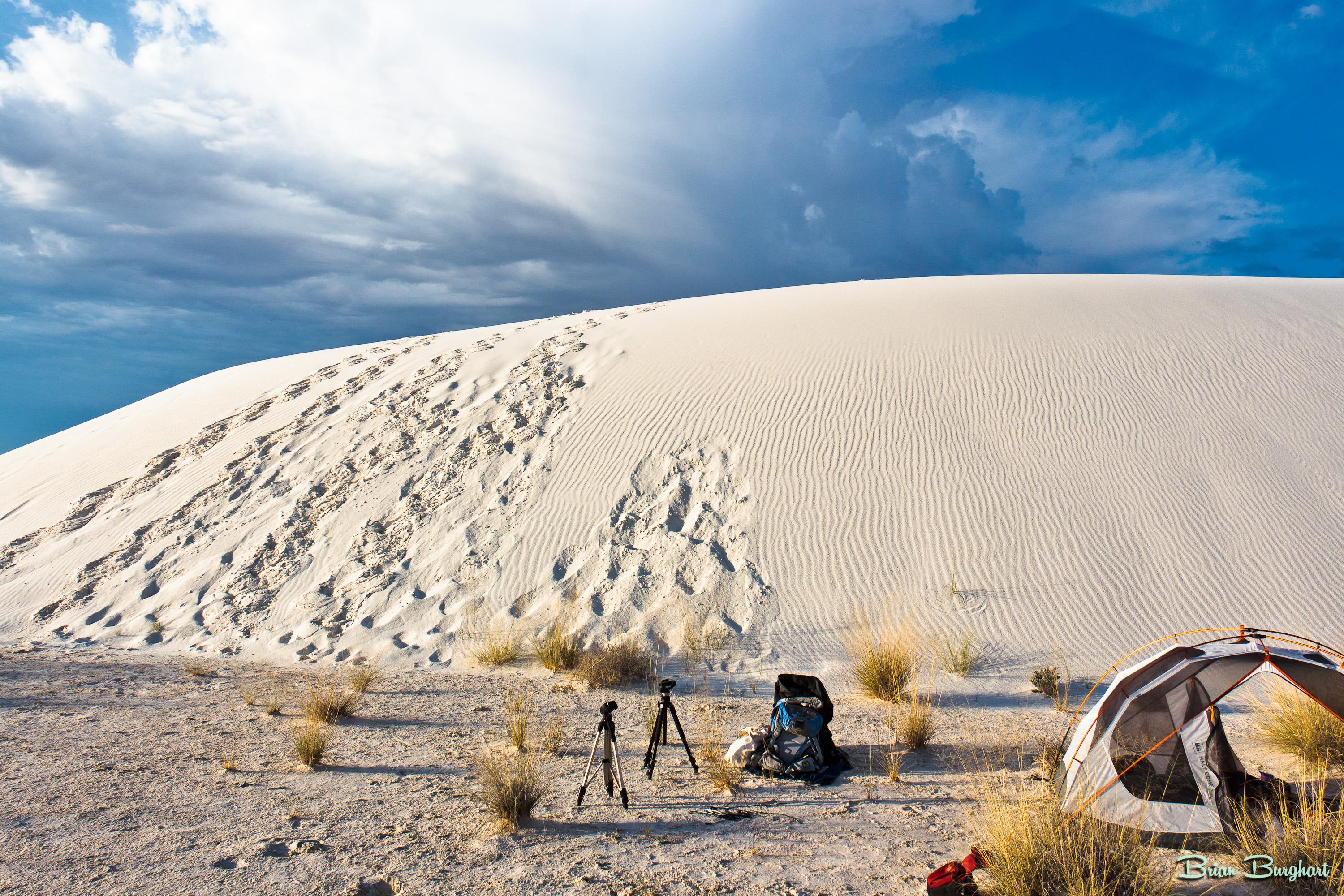 A tent, backpack, and camera equipment at a backcountry camping site.