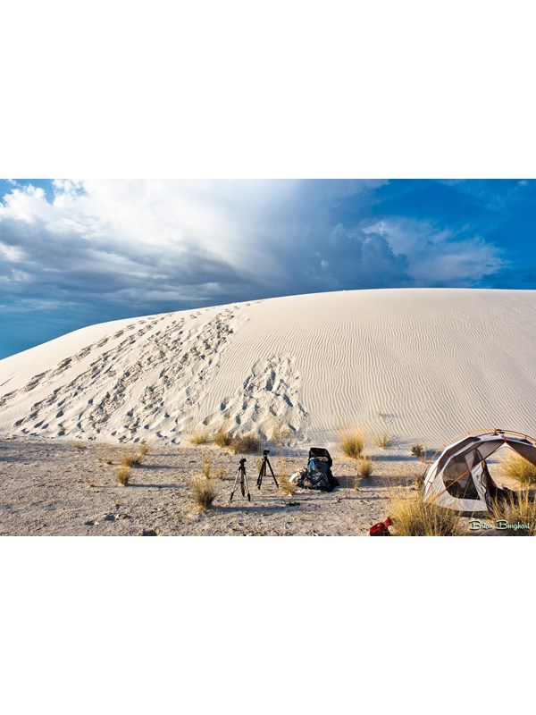 A tent, backpack, and camera equipment at a backcountry camping site.