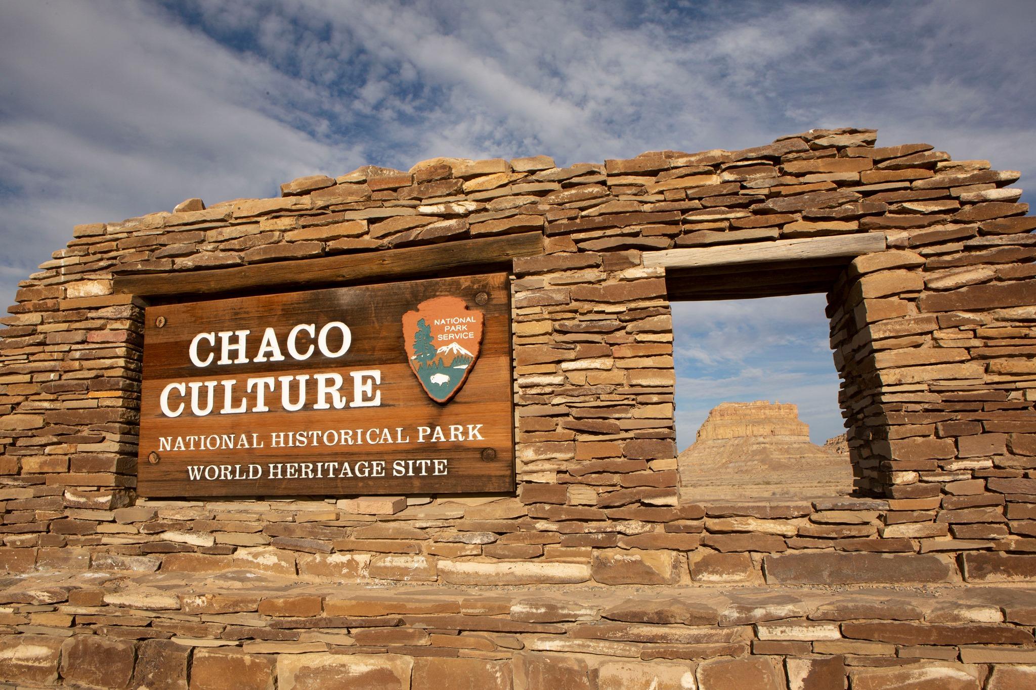 The entrance sign to Chaco Culture made out of sandstone and showing Fajada Butte through a window.