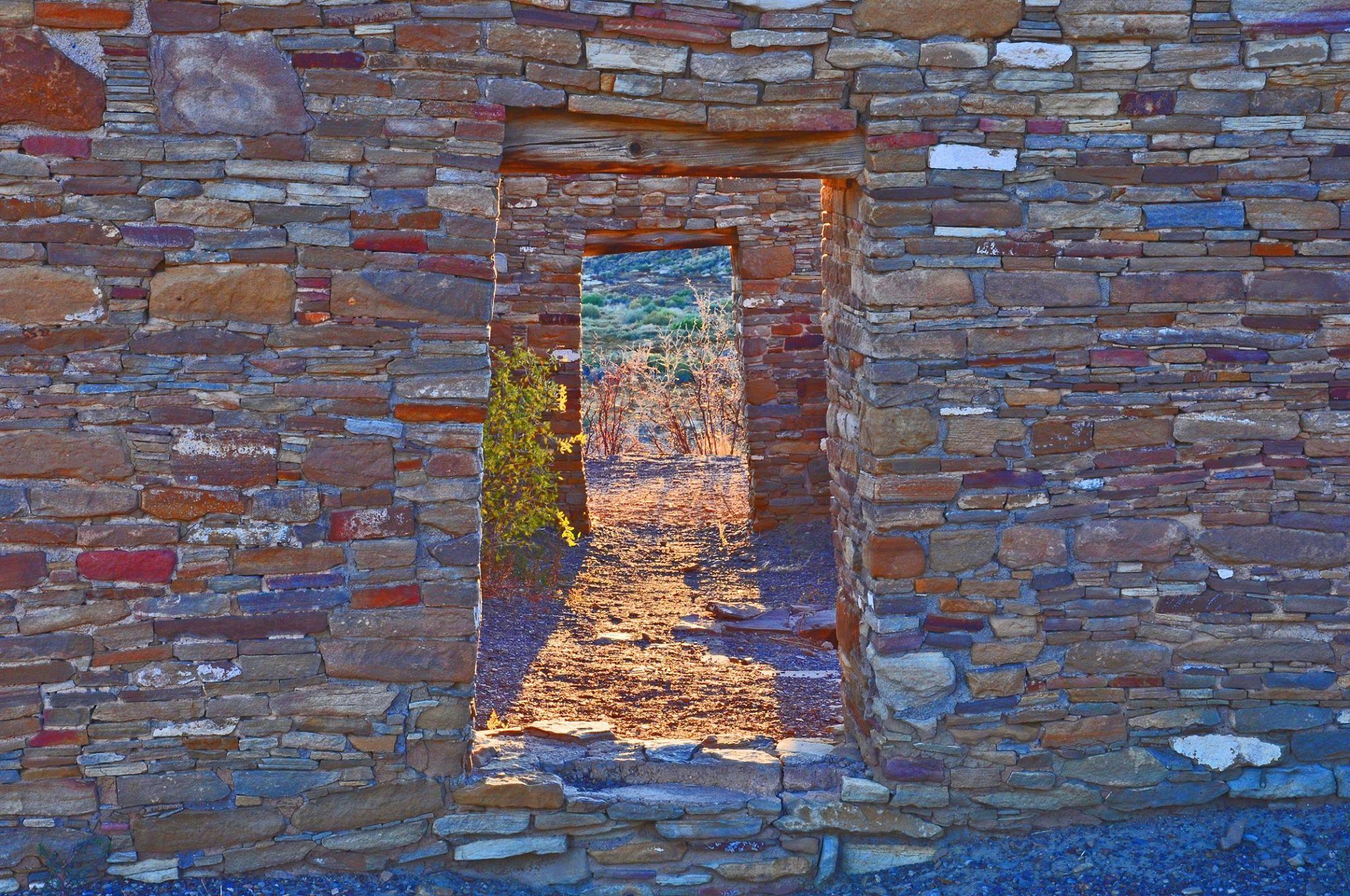 Colorful sandstone walls with two open sections in the middle that look like doorways.