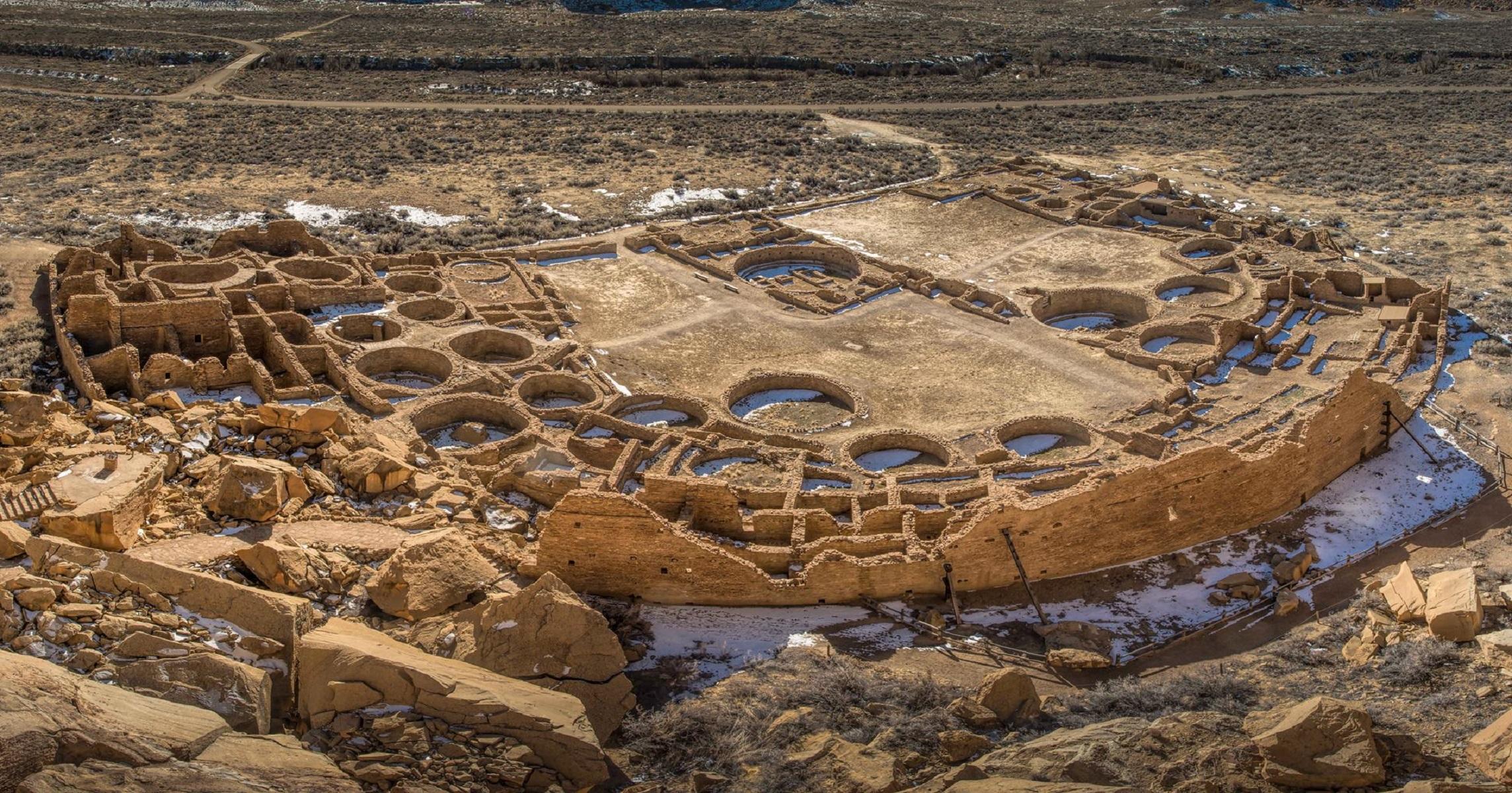 An aerial view of the Pueblo Bonito great house showing many rooms and circular kivas.