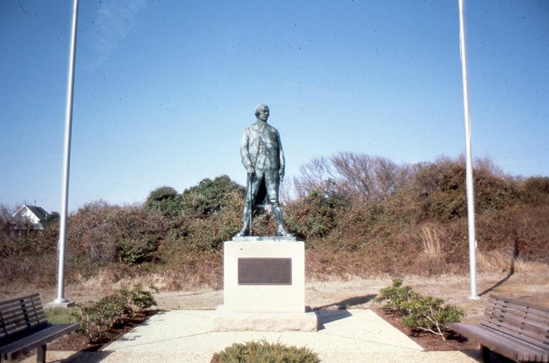 Admiral de Grasse Statue Patinaed statue of a military officer flanked by flagpoles and benches