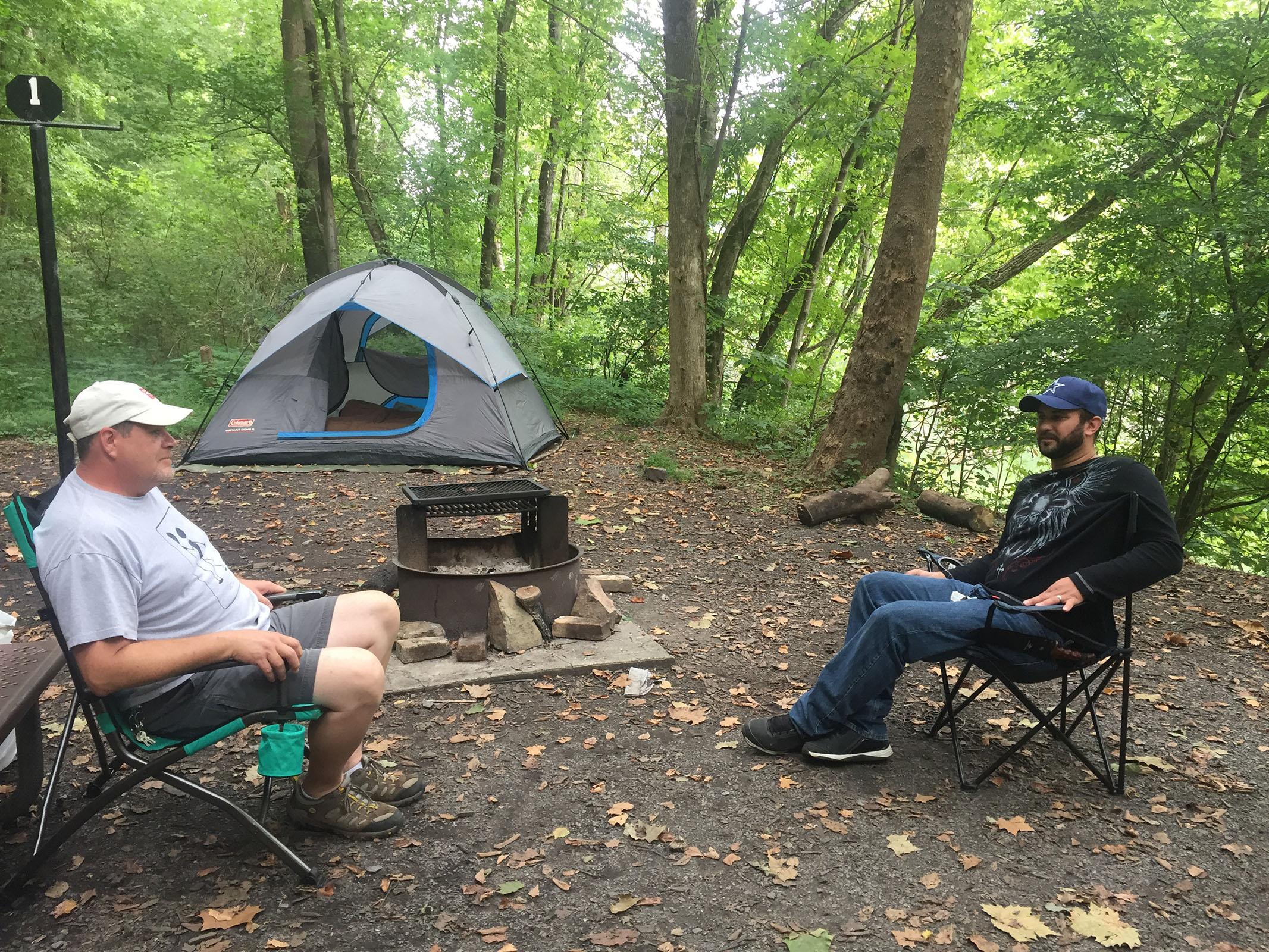 campers sitting in front of tent