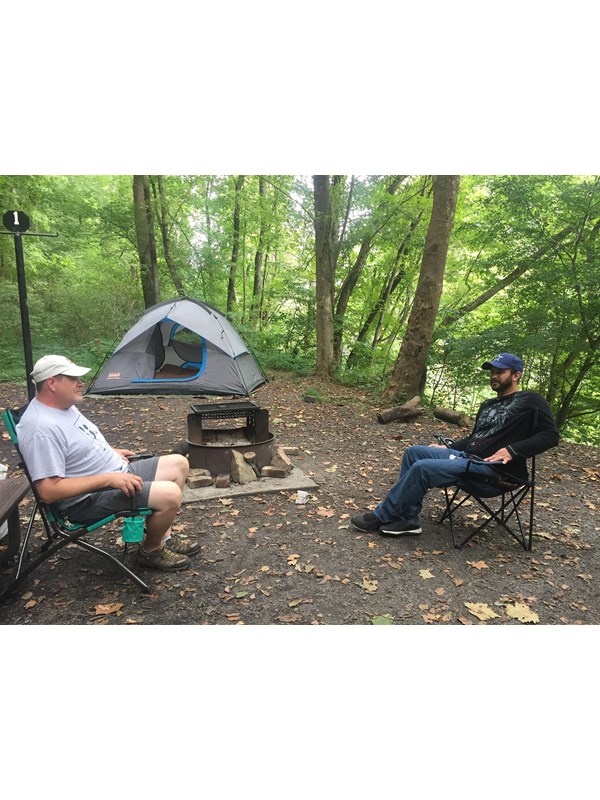 campers sitting in front of tent