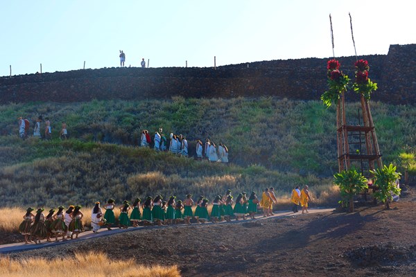Ceremony procession along a heiau at sunrise.