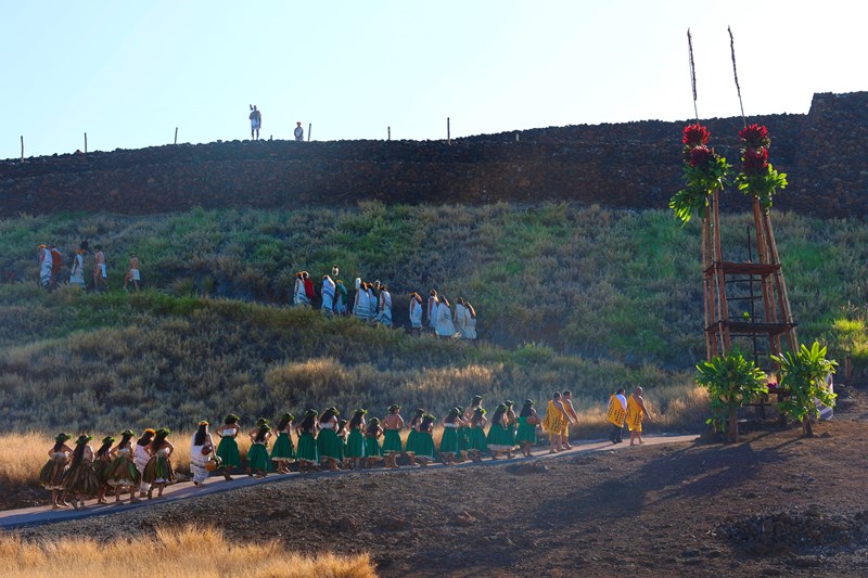 Ceremony procession along a heiau at sunrise.