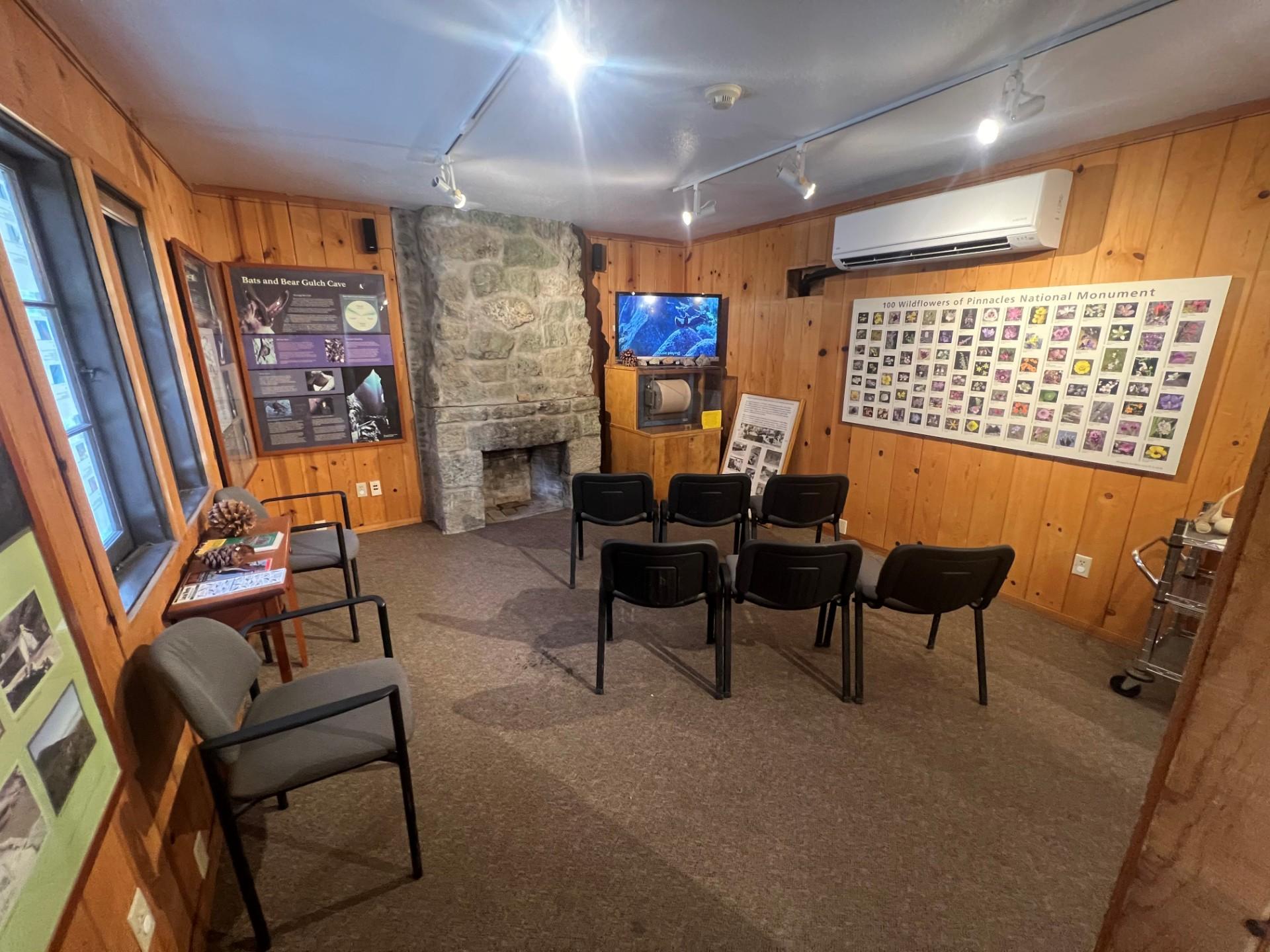 Chairs set up in front of a TV sitting on a seismograph surrounded by interp displays found on walls