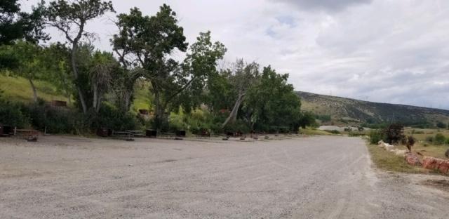 A gravel road with several side by side campgrounds lining the left side.