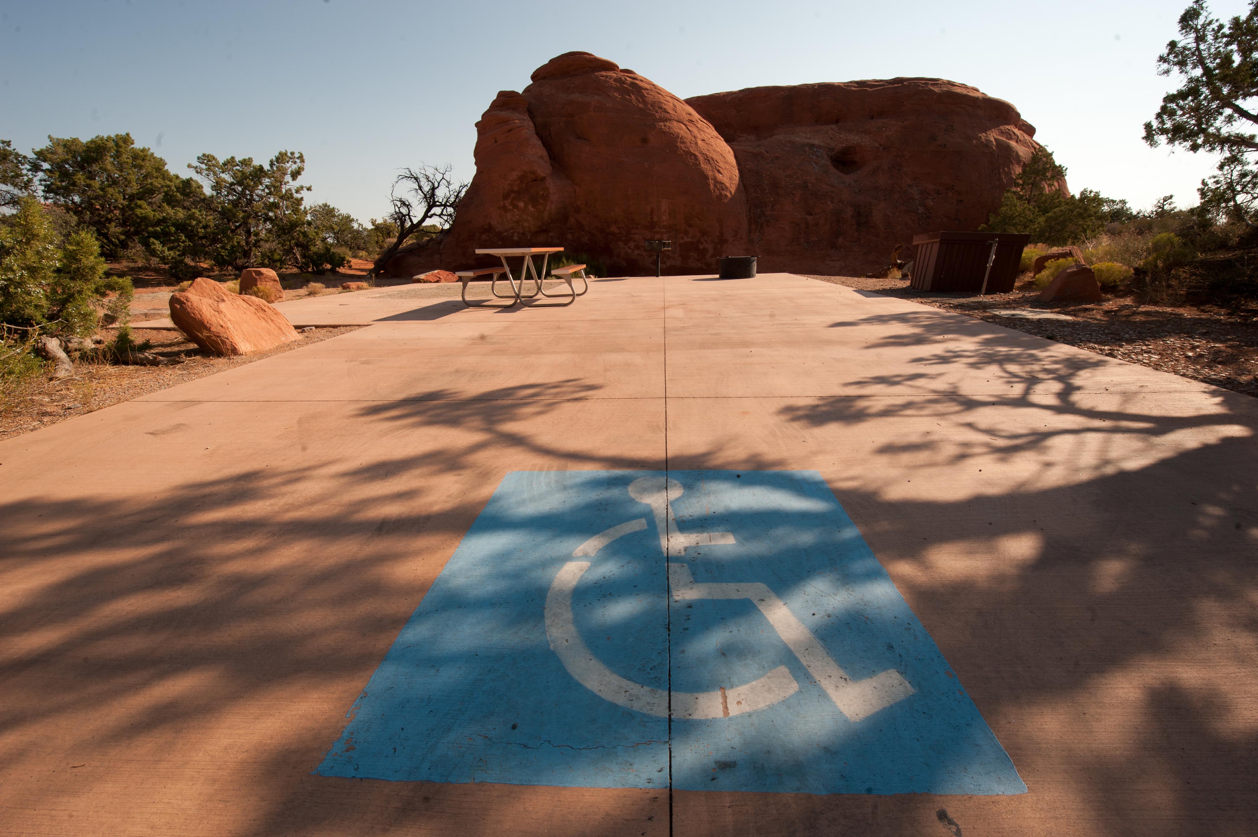 a paved campsite with a large blue accessible image painted on the ground