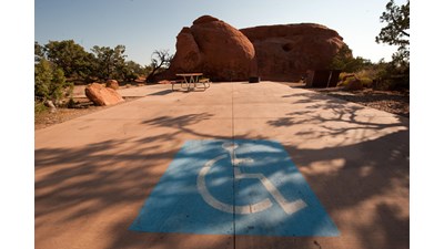 a paved campsite with a large blue accessible image painted on the ground