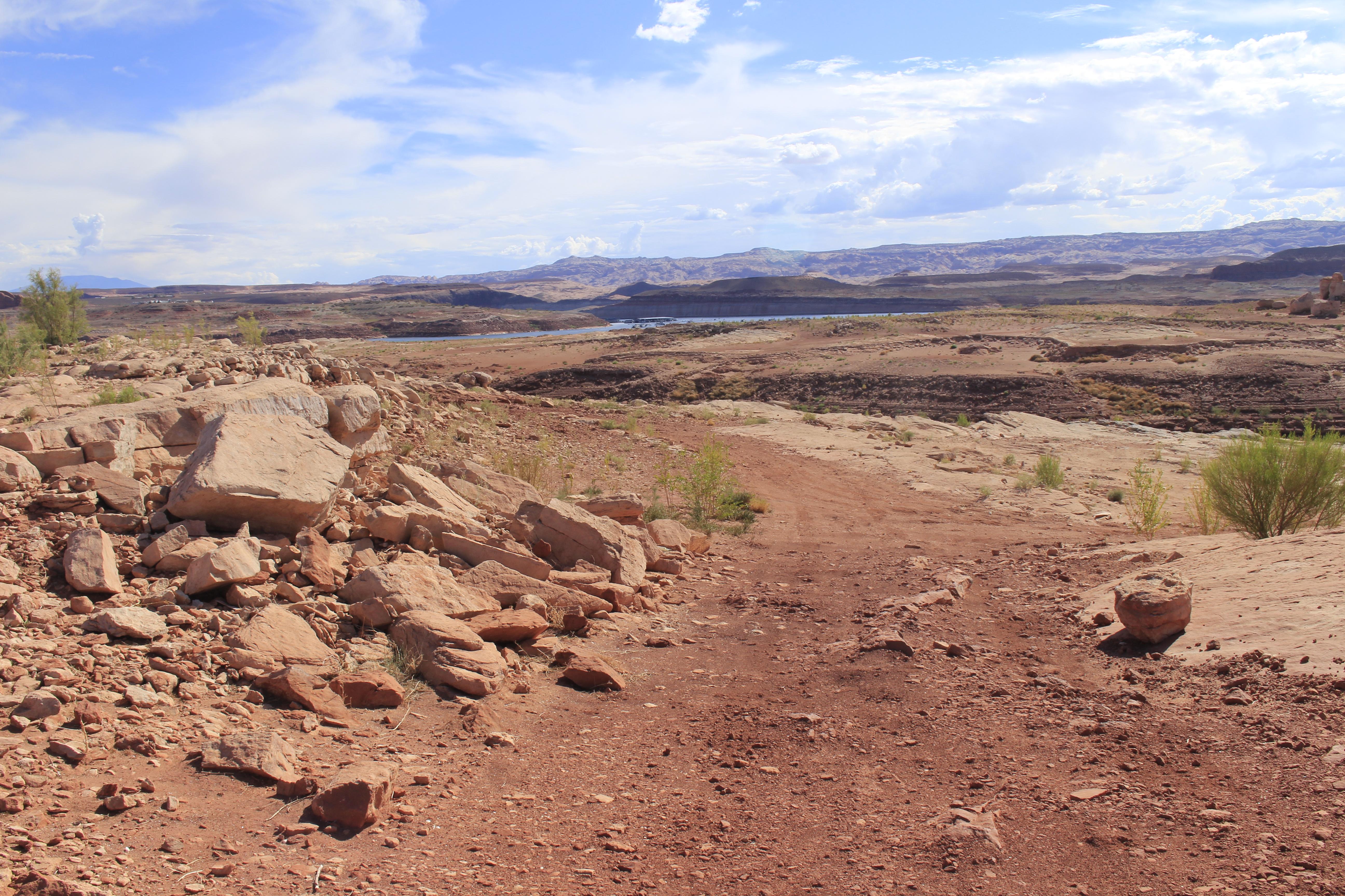 Red sand and sandstone features. Dark mountain in the background.