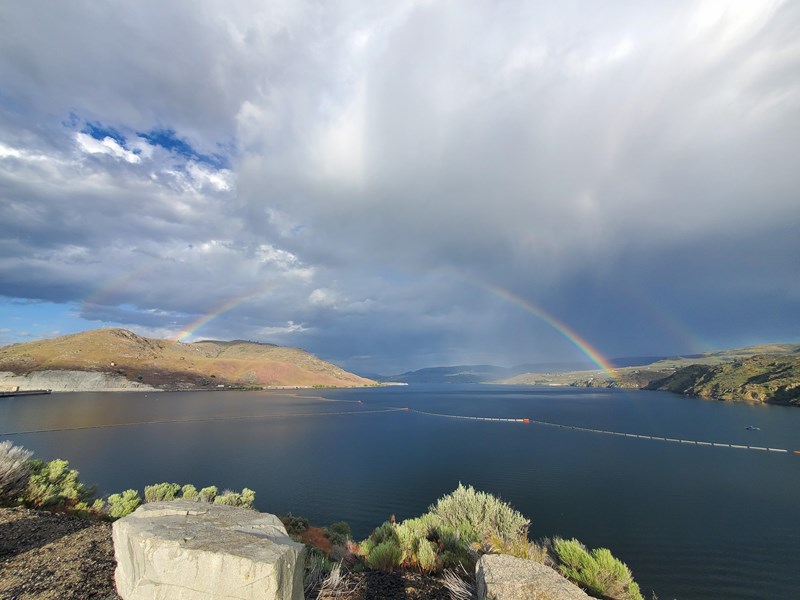 Lake Roosevelt Crescent Bay Rainbow Stormy clouds over a blue lake with a rainbow stretching from one side of the lake to the other.