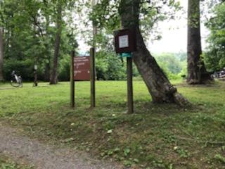 Campsite signs in front of a grassy area.