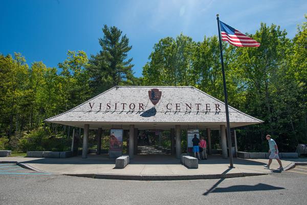 Outdoor structure with visitor center spelled across roof provides cover for information displays.