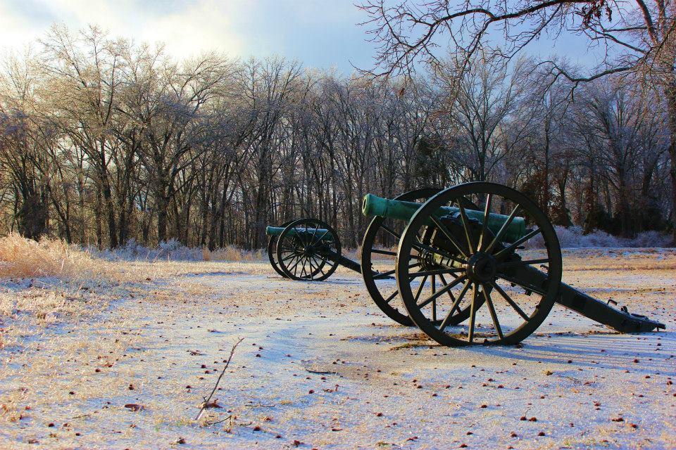 Two cannons sit in an icy field.