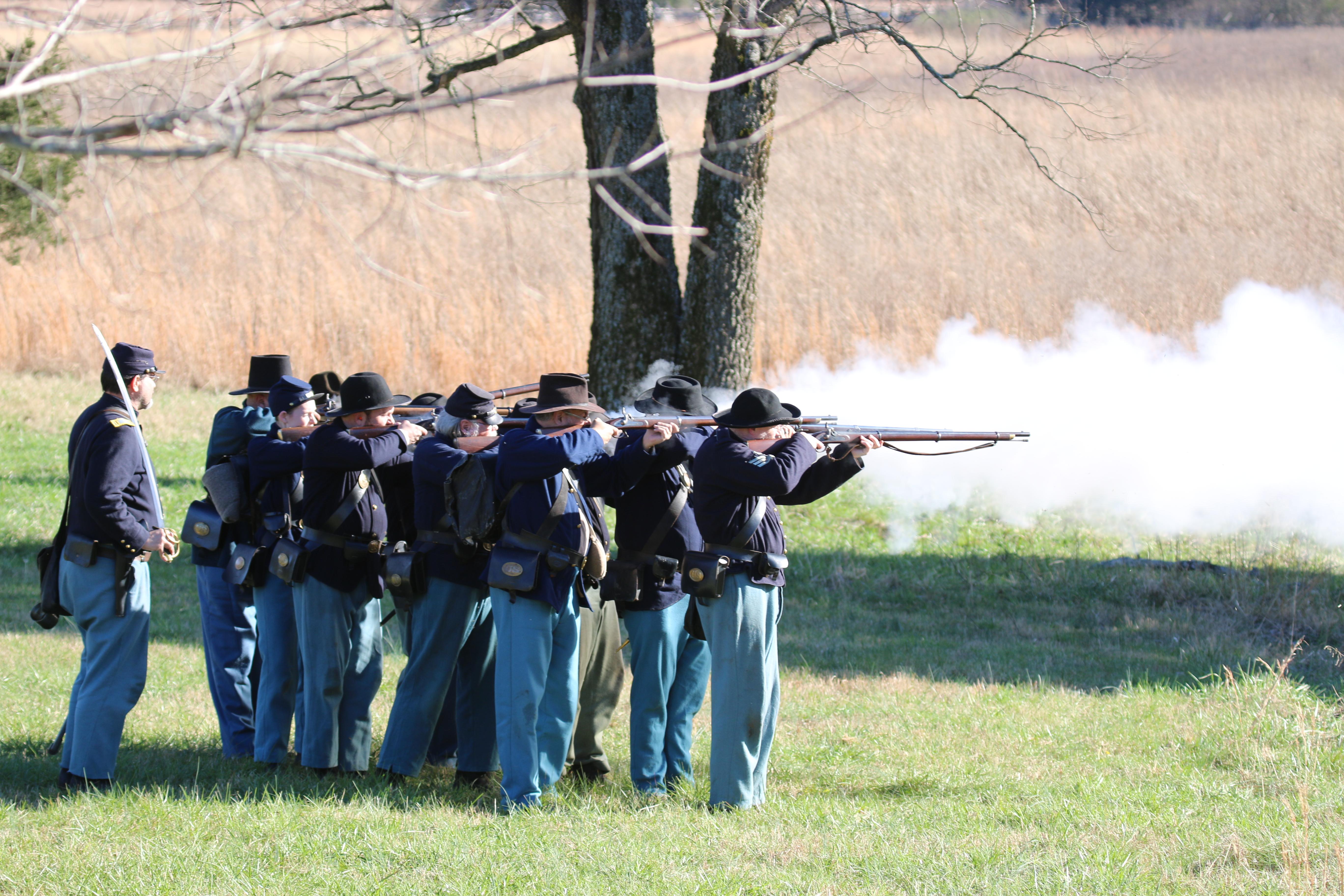 Union soldiers fire muskets.