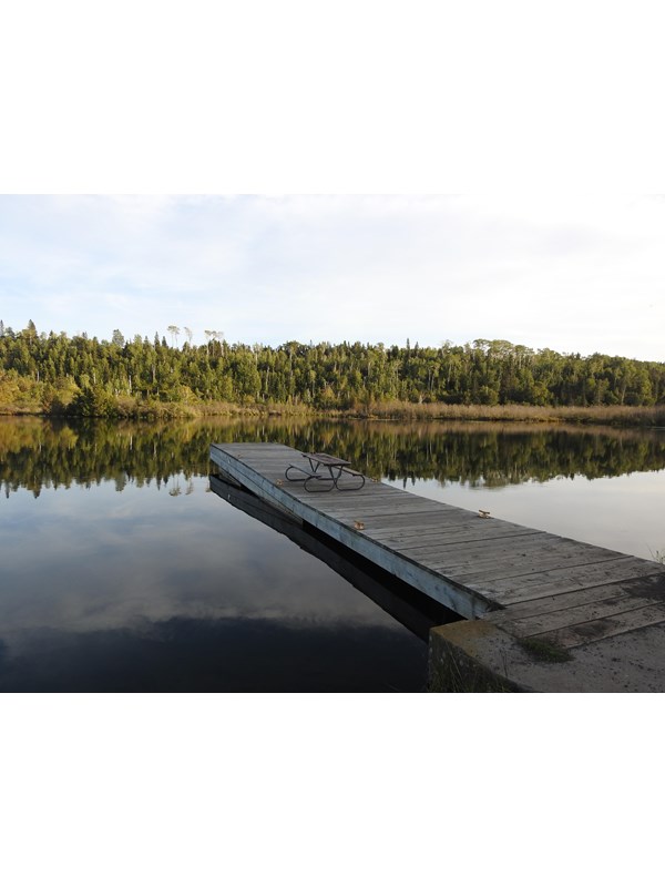 Dock stretching into McCargoe Cove. Shoreline visible across cove.