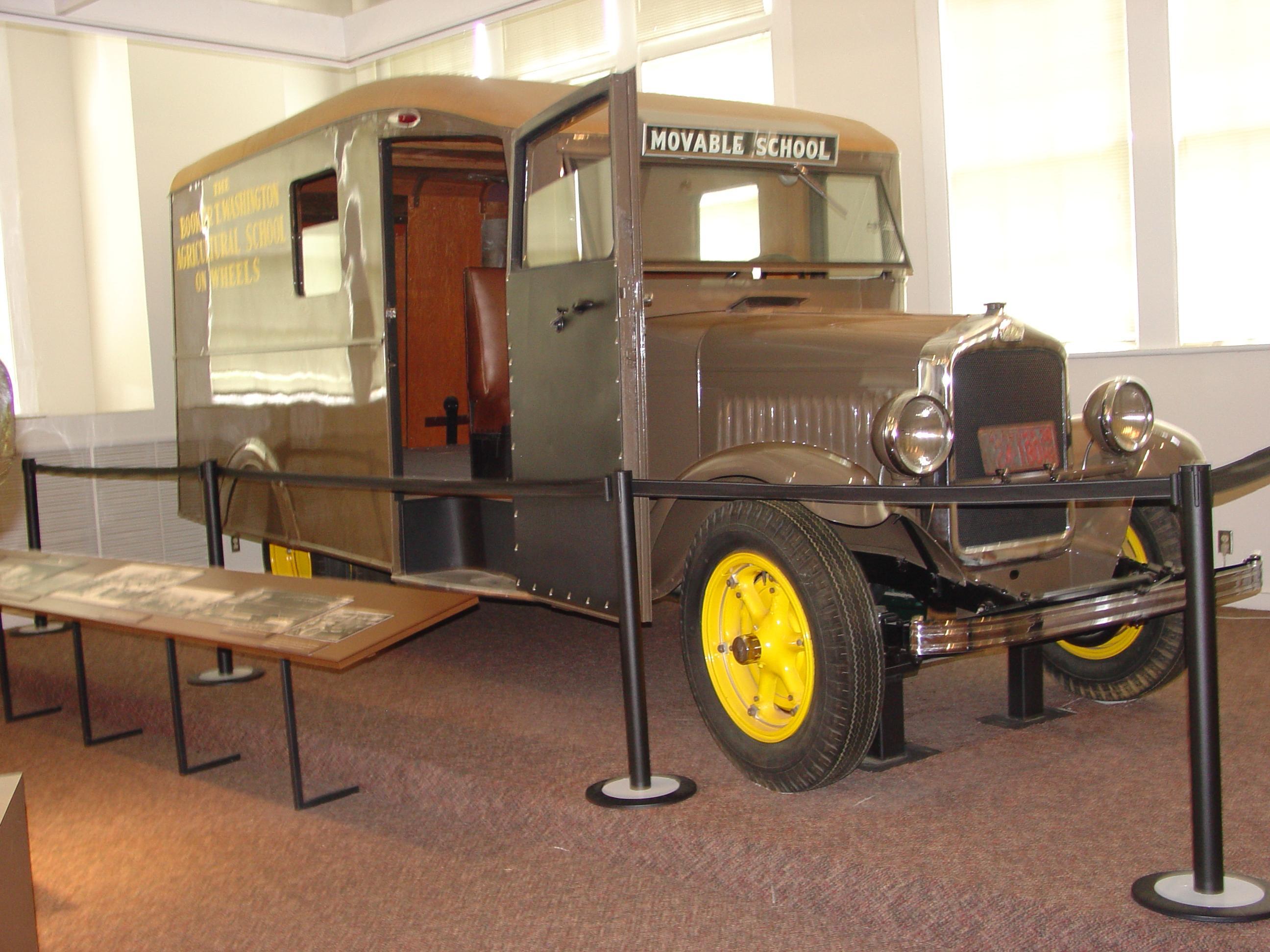 A brown colored modified school bus with two windows