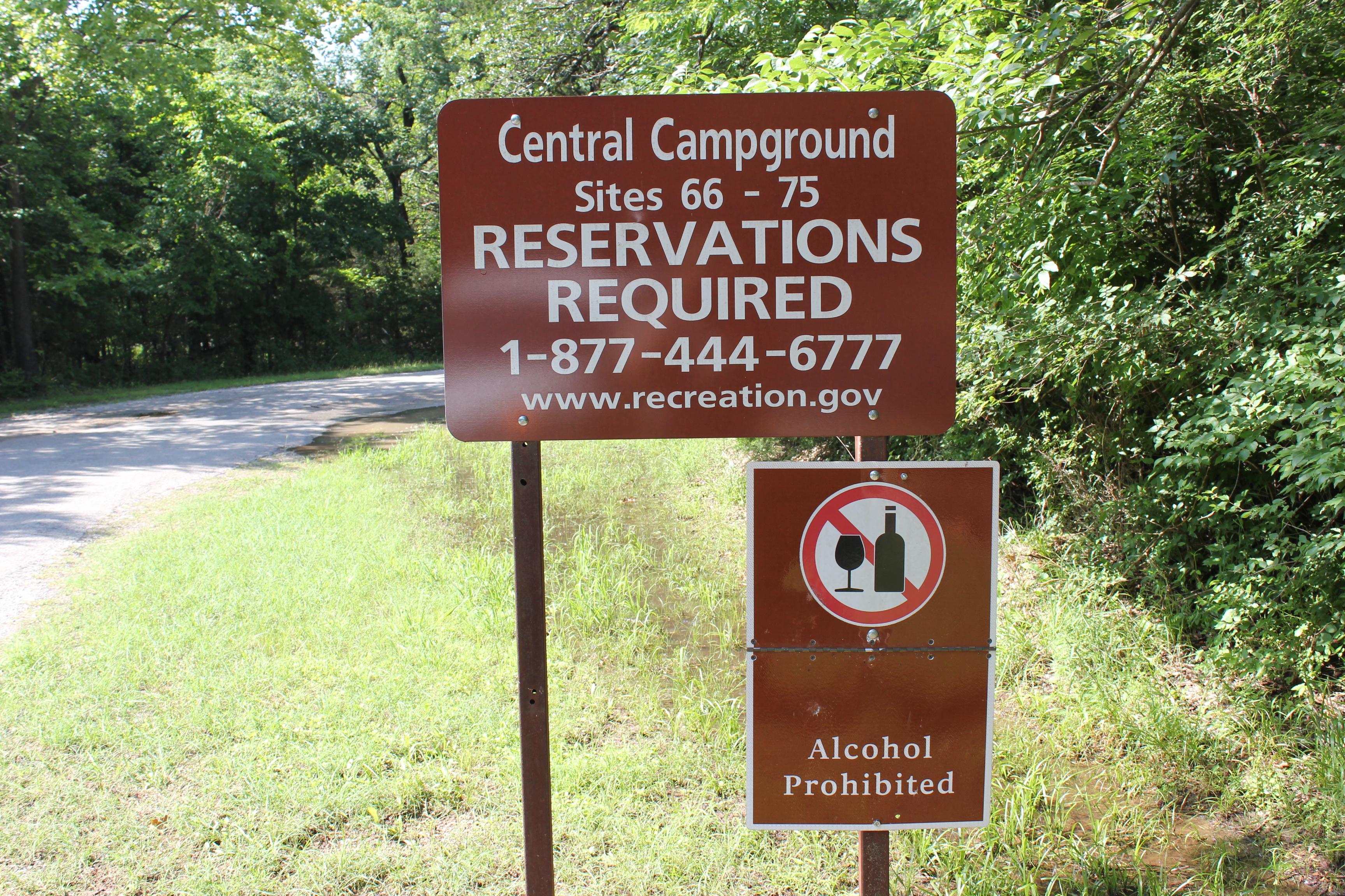 A brown entrance sign for Central Campground, stating that reservations are required.