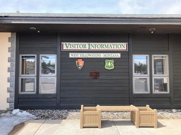 Signs indicating visitor information, NPS, Forest Service on the side of the building