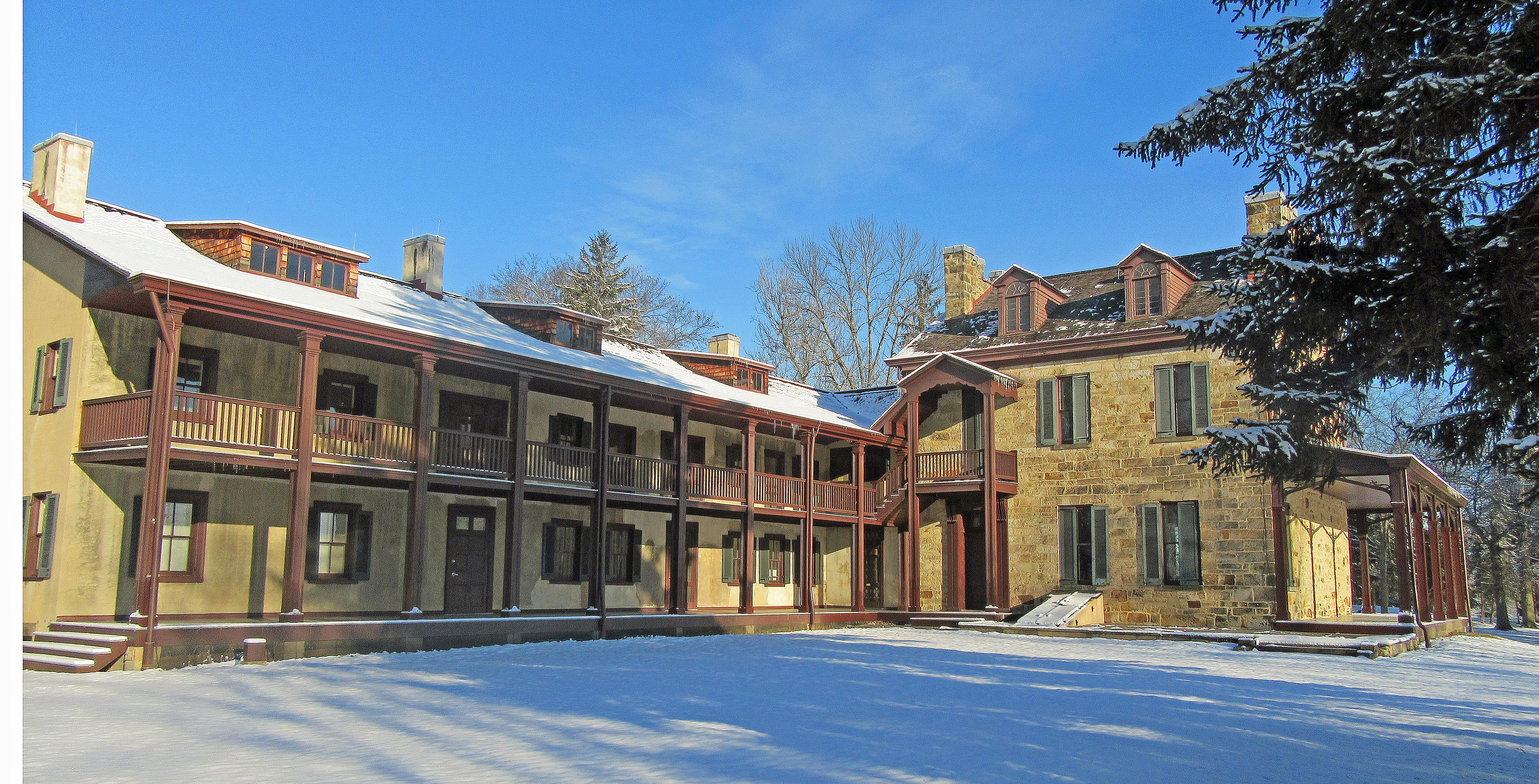 Gallatin House - Stone House and South Wing in snow with blue sky