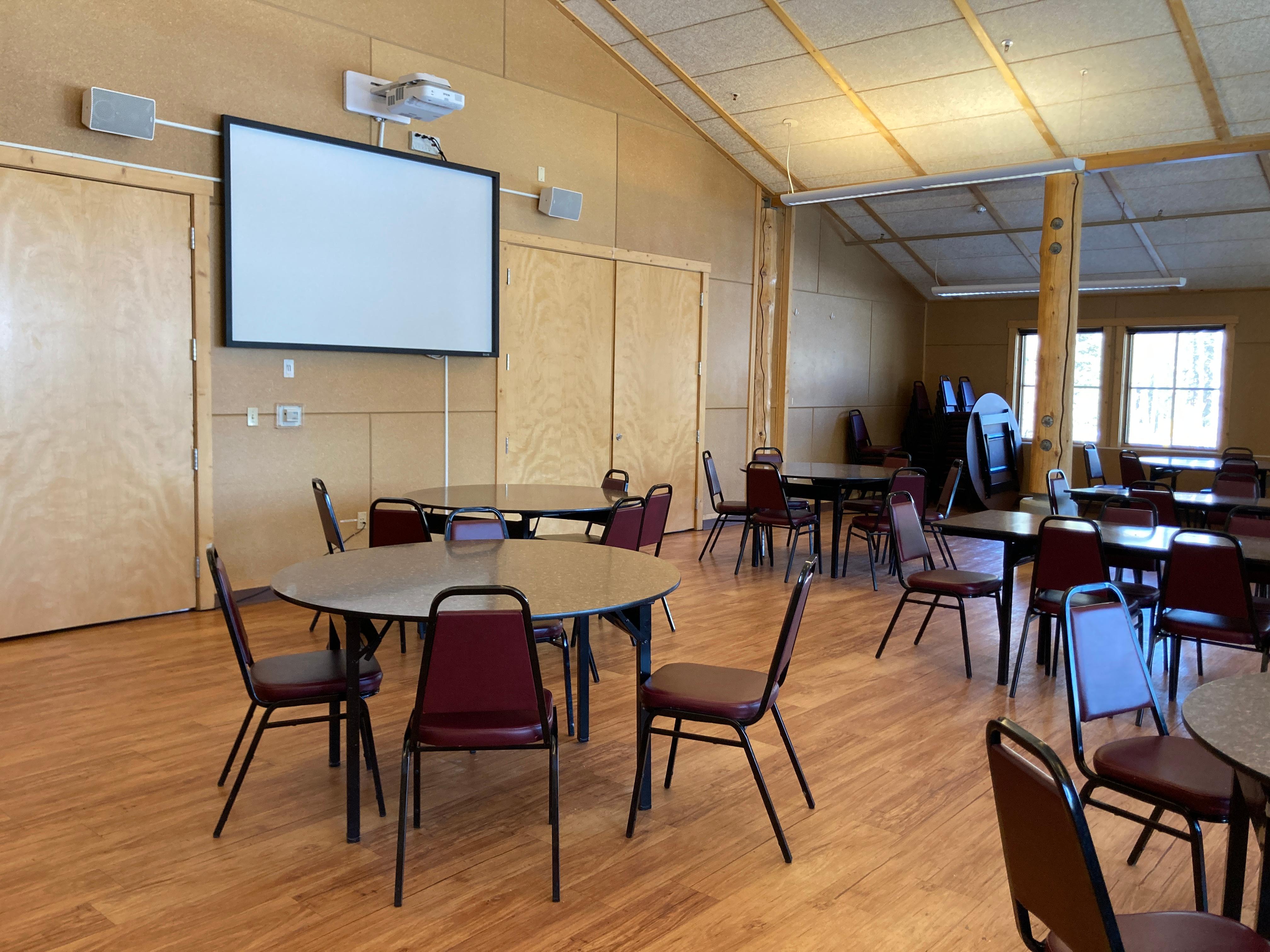 A room of small round tables, with four chairs at each table.