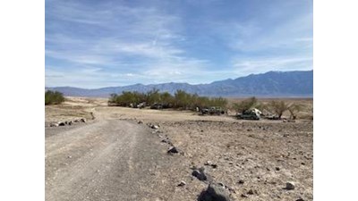 Dirt road leading into camping area with mountains in the background