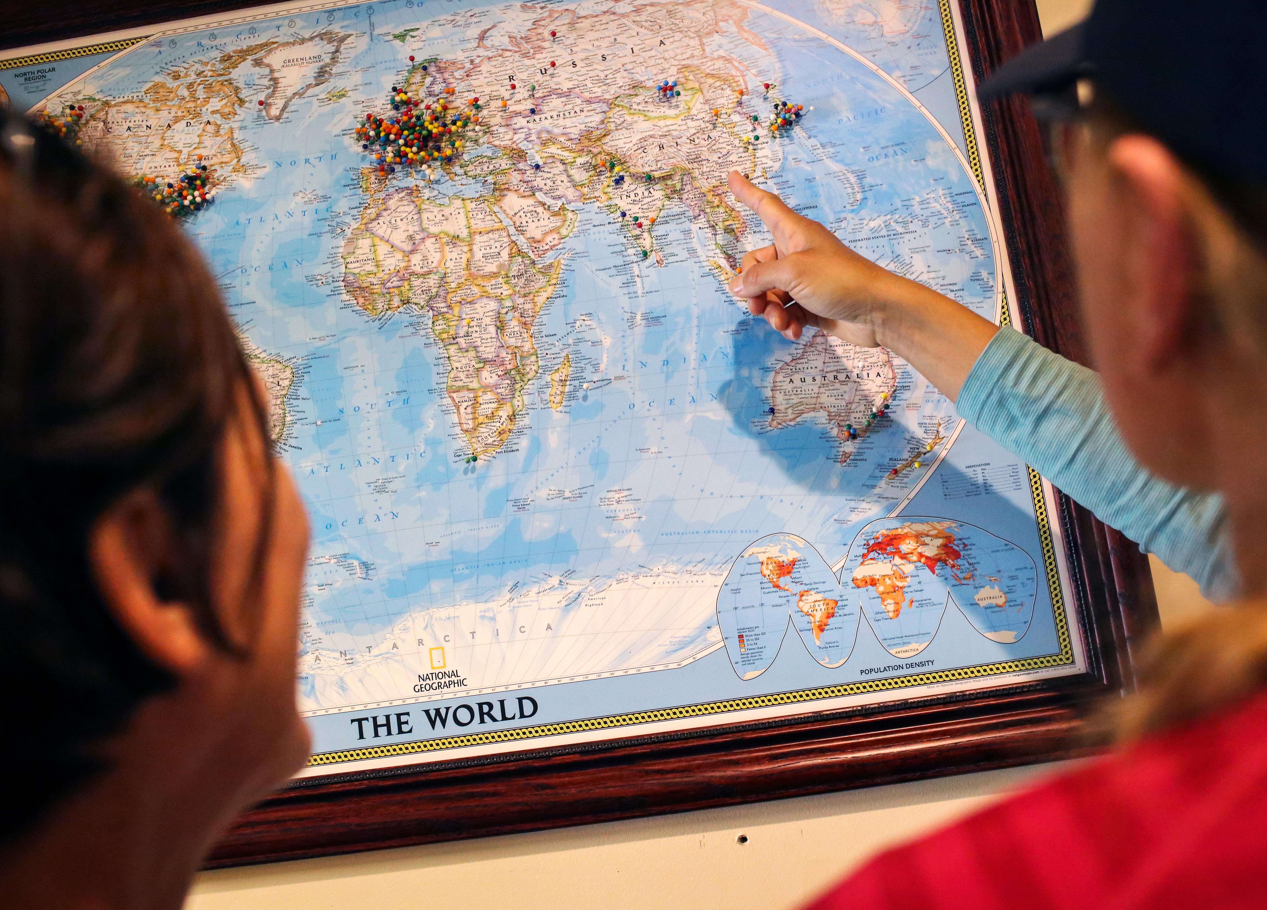 A map of the world with hundreds of push-pins stuck into it