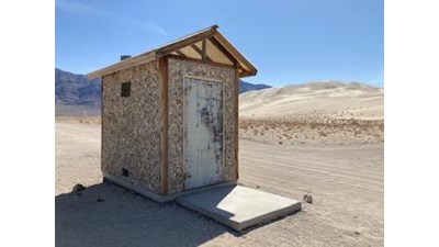Vault toilet with sand dune in the background