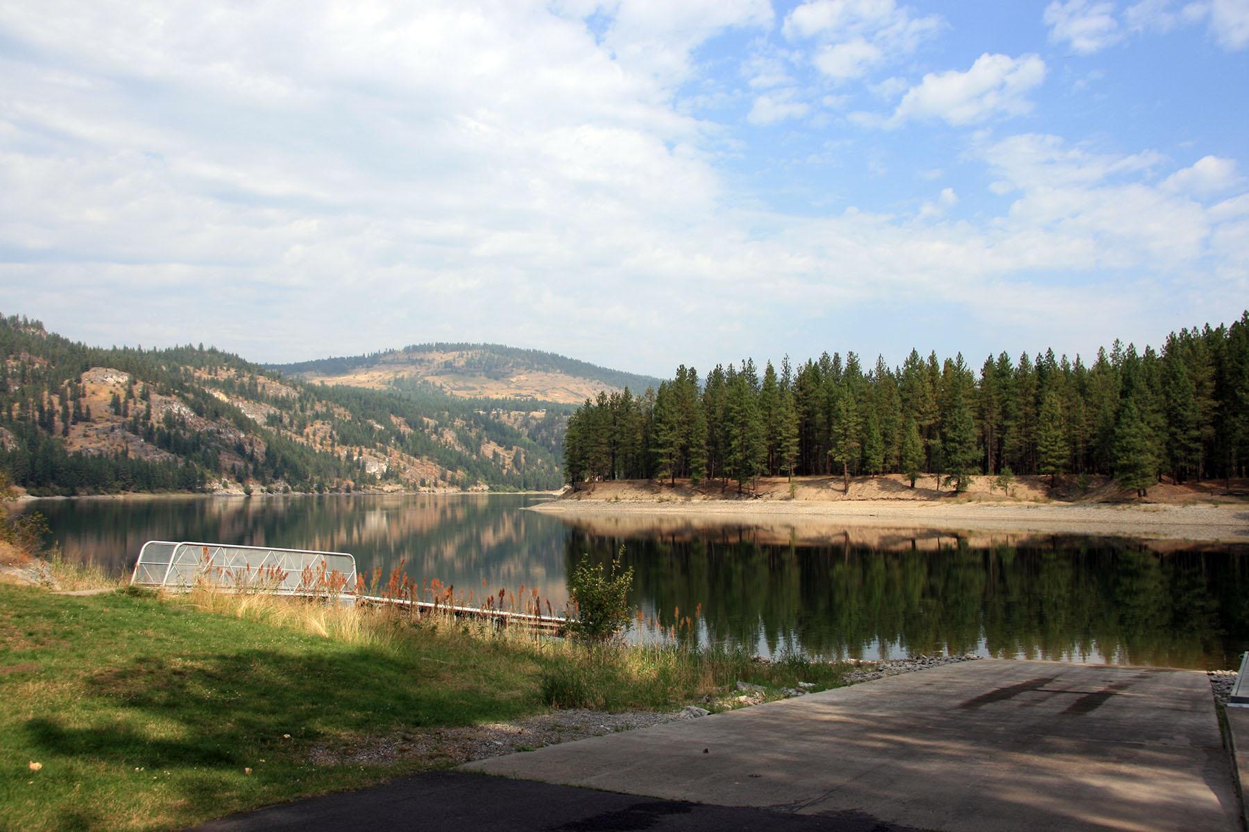 a cement boat launch and adjacent courtesy dock lead into the mirror-like lake