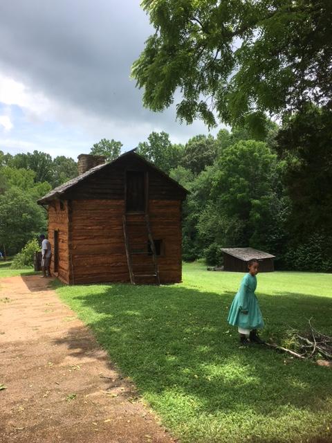 Kitchen cabin with child in green dress in front