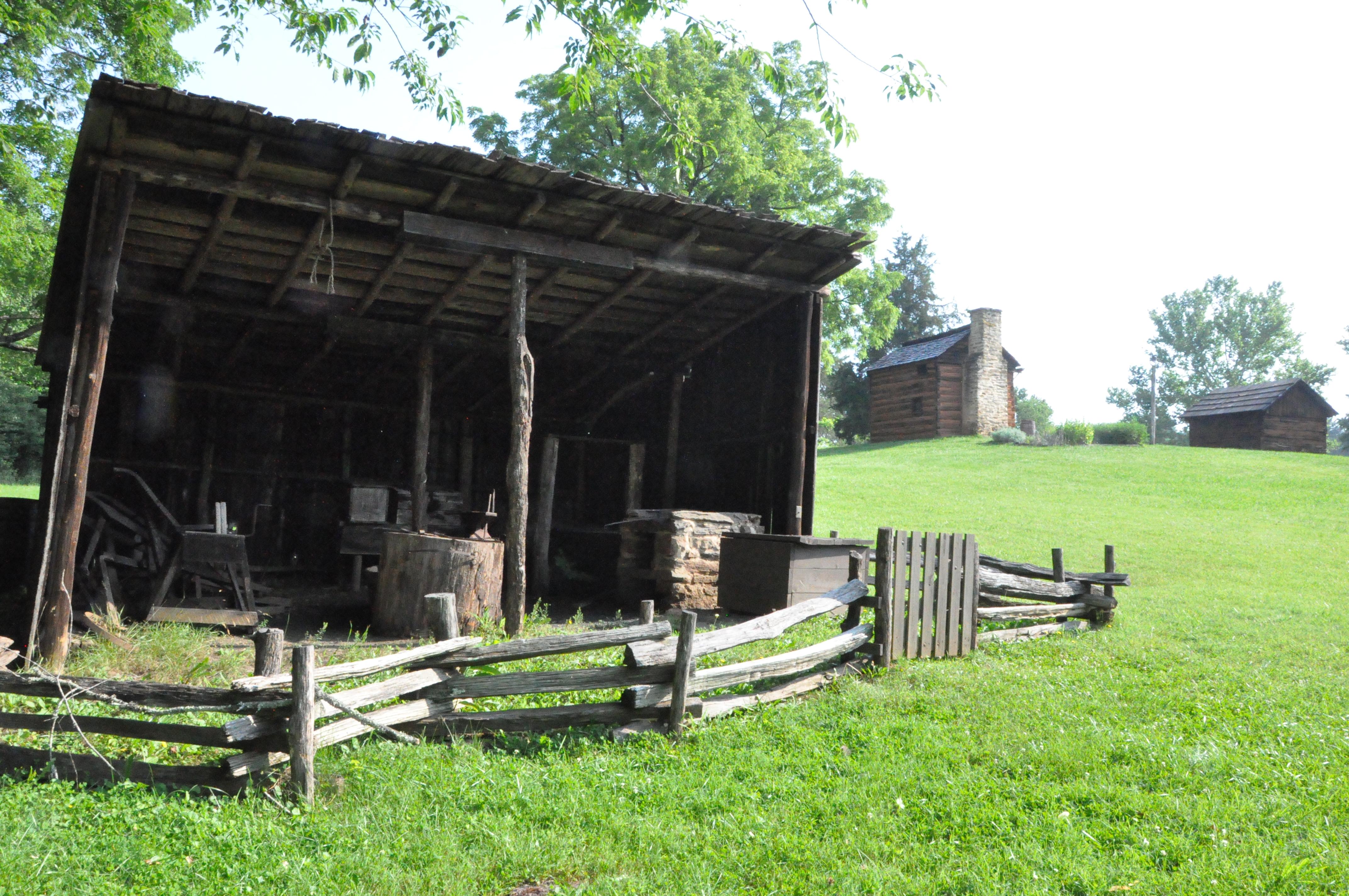 Blacksmith shed with kitchen cabin and smokehouse uphill in back ground