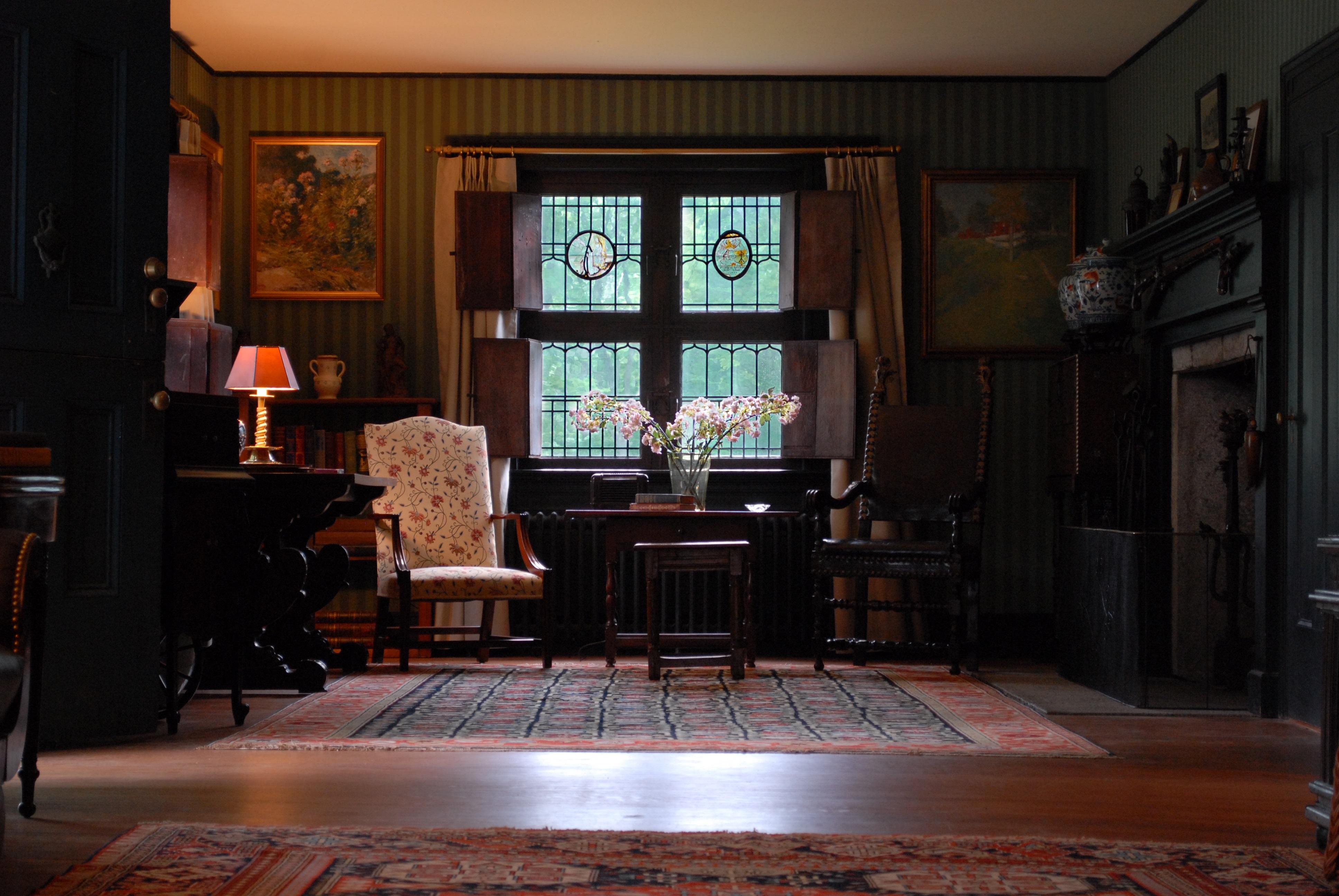 The inside of a living room with two arm chairs and a table in between.