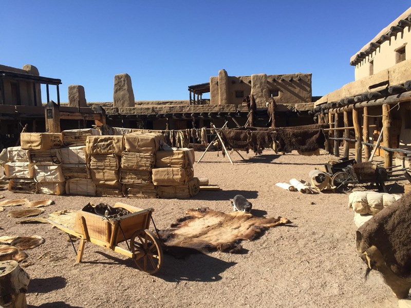 Boxes and Furs Wooden boxes and buffalo furs are scattered around a plaza inside an adobe fortification.